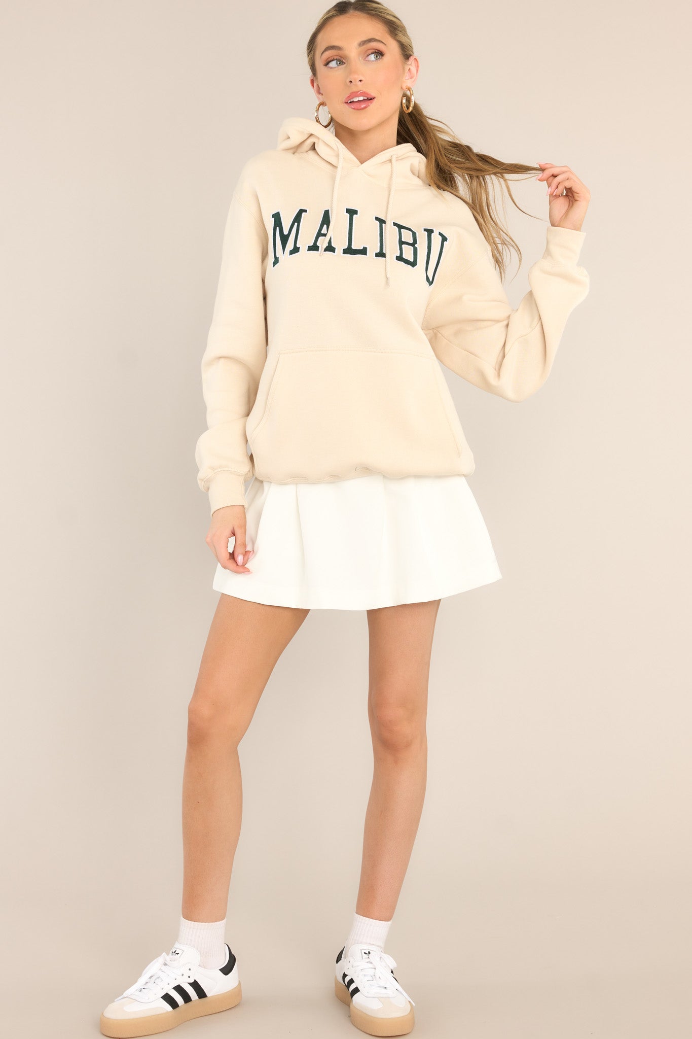 Full body view of this hoodie that features embroidered "Malibu" text, a drawstring hood, and a kangaroo pocket.