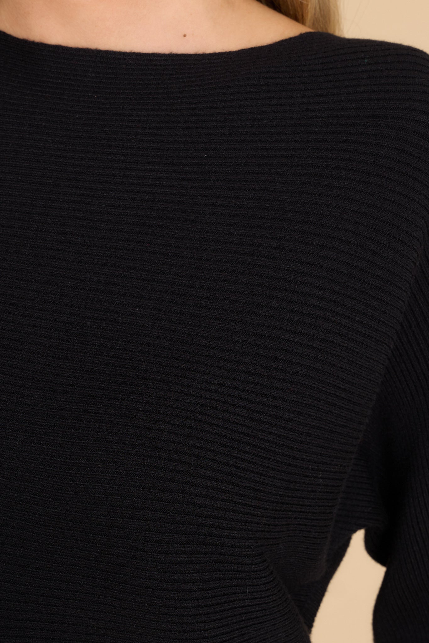 Close up view of this sweater that features a round neckline and a soft stretchy material.