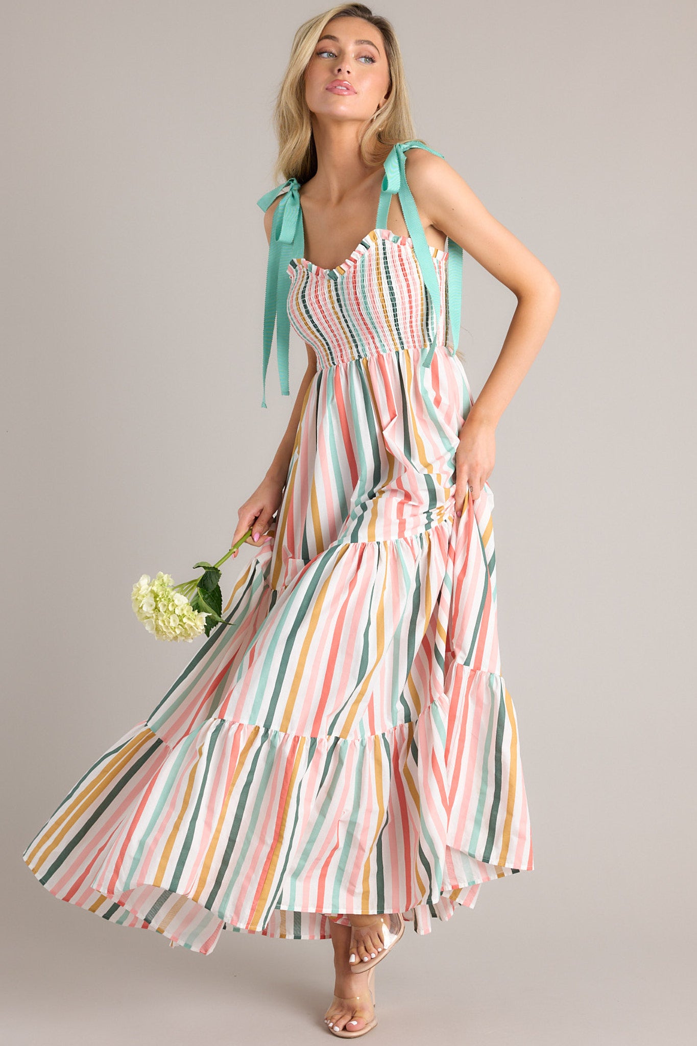 Full body view showing the movement of this dress that features a v-neckline, adjustable self-tie straps, a smocked bust, and flowy tiers down the skirt.