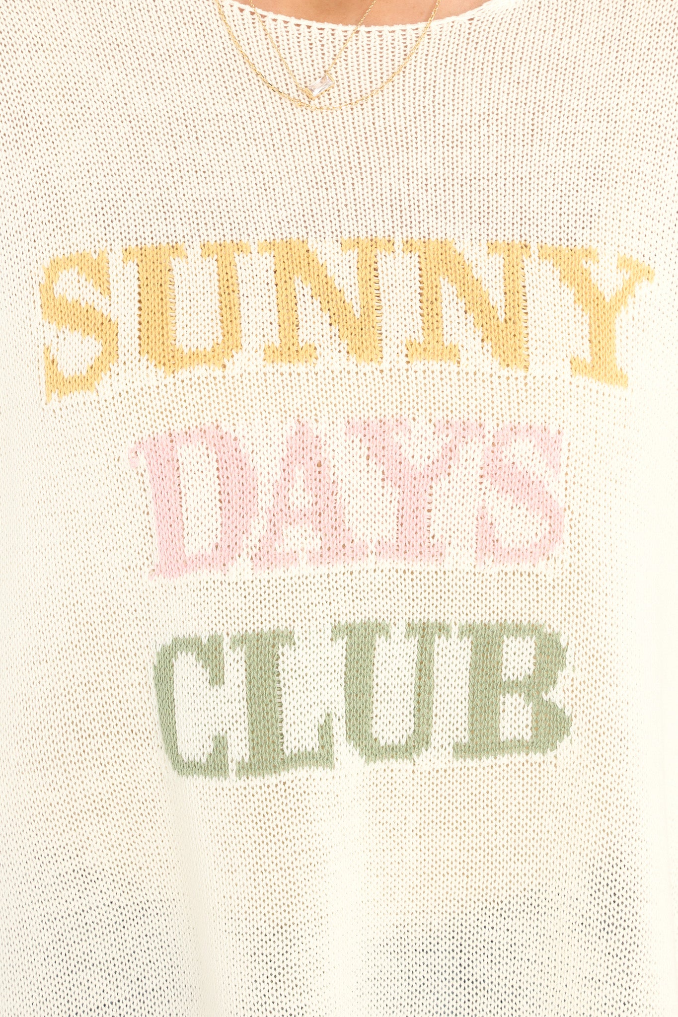 Detail view of this top that features "Sunny Days Club" on the front and a light weight knit fabric.