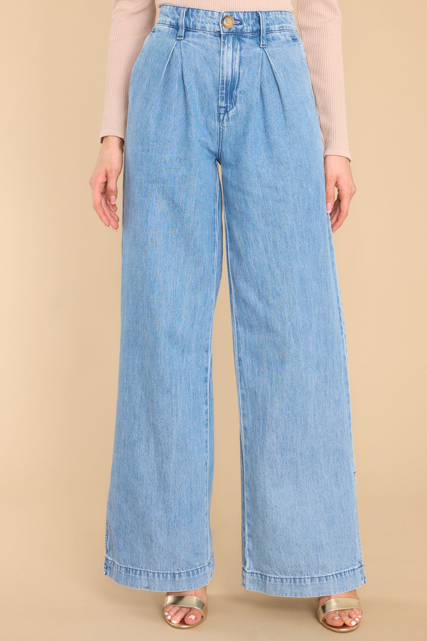 Front view of these pants that feature a high rise waist, a functional zipper, four functional pocket detailing, and a wide leg with side slits.