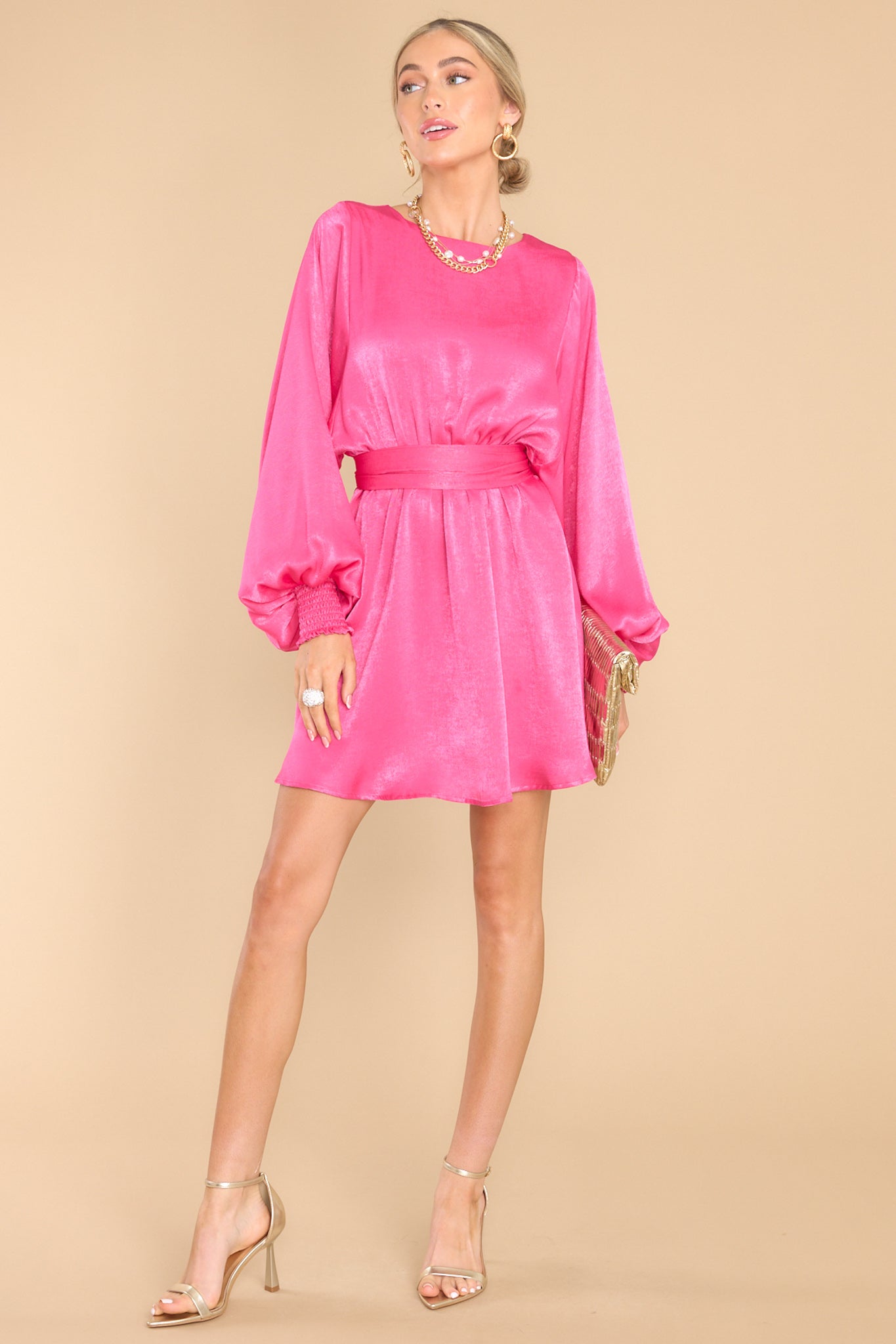 Full body view of this dress that features a round neckline, a keyhole with a button closure on the back, flowy sleeves with smocked cuffs, an elastic waistband, a self-tie, and a flowy skirt.