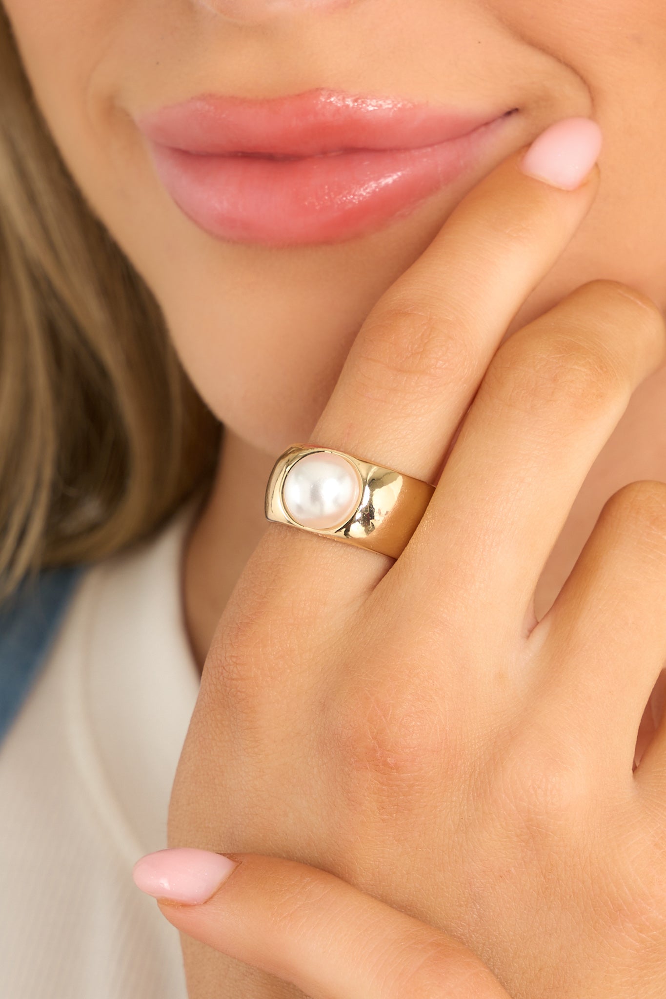 This gold ring features a thick band and a faux pearl.