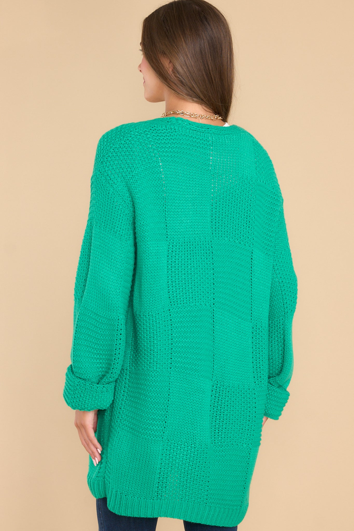 Back view of this cardigan that features a chunky square knit design with long sleeves and ribbed cuffs.