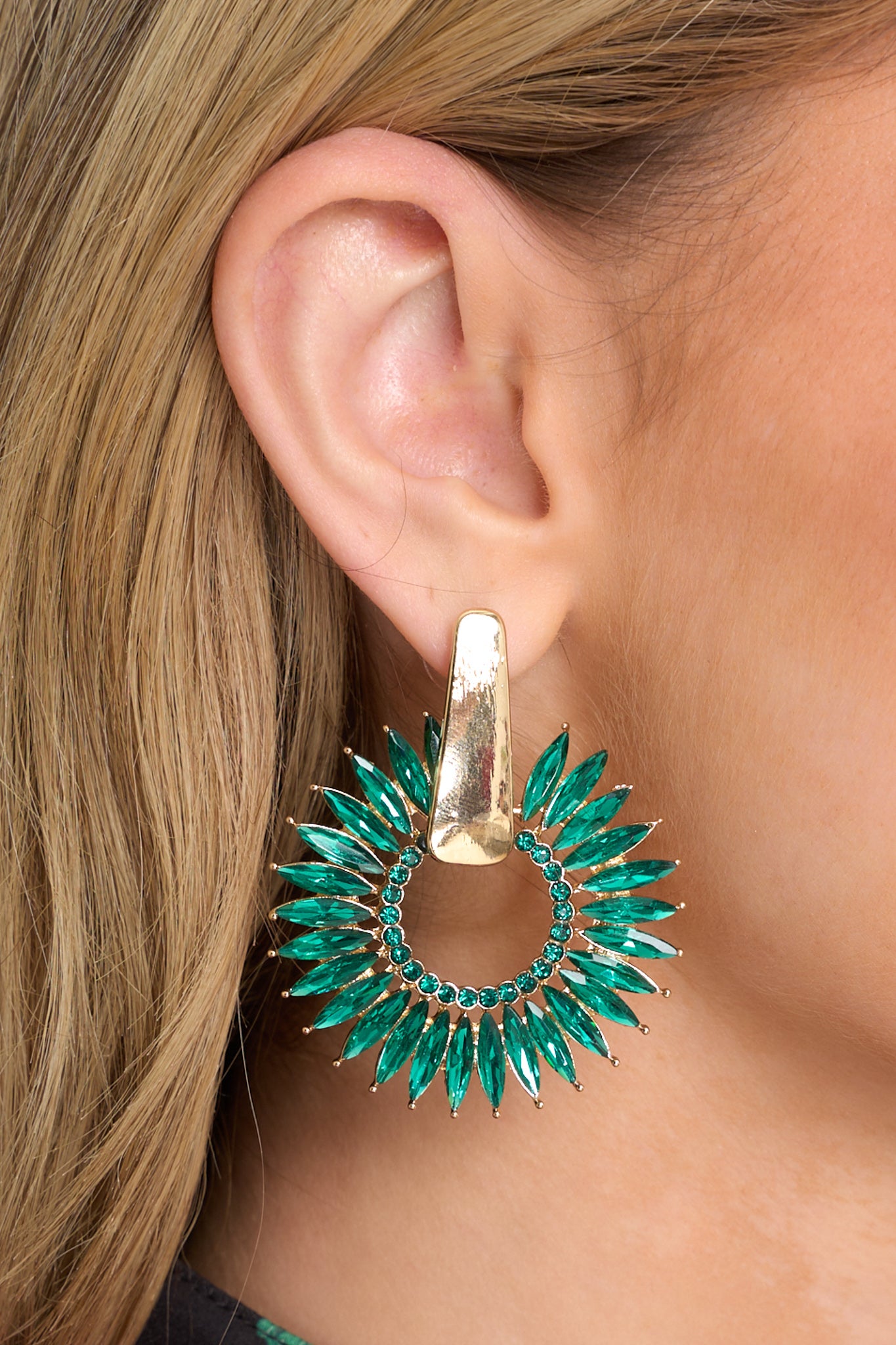 These earrings feature gold hardware, rhinestone detailing, a fanned-out hoop design, and a secure post backing.