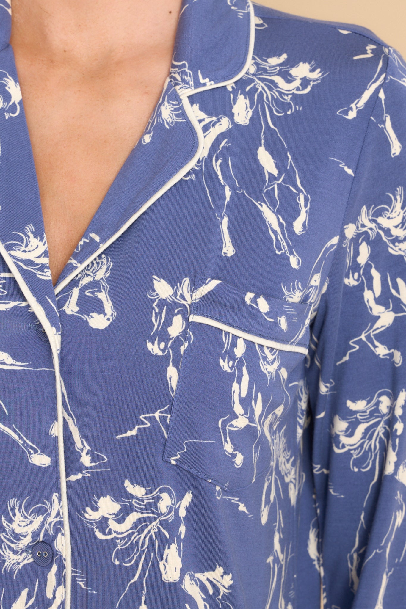 Close up view of this nightshirt that features a collared neckline, functional buttons down the front, a functional front pocket on the left side of the bust, and a round hem. 