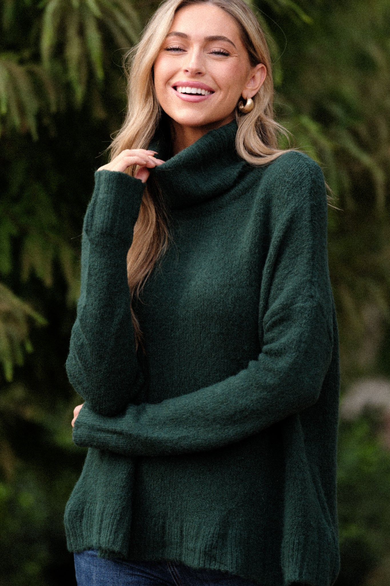 Full body view of this sweater that features a very light eyelash knit design and a turtle cowl neckline.