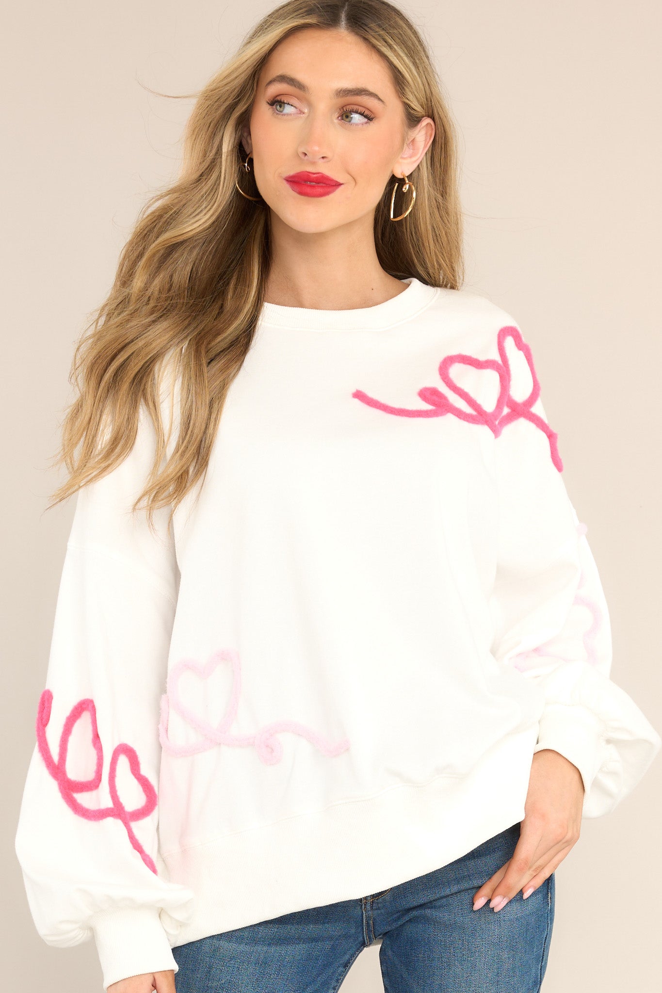 Front view of this sweatshirt that features a crew neckline, textured whimsical heart detailing, ribbed cuffed bishop sleeves, and a ribbed hemline.