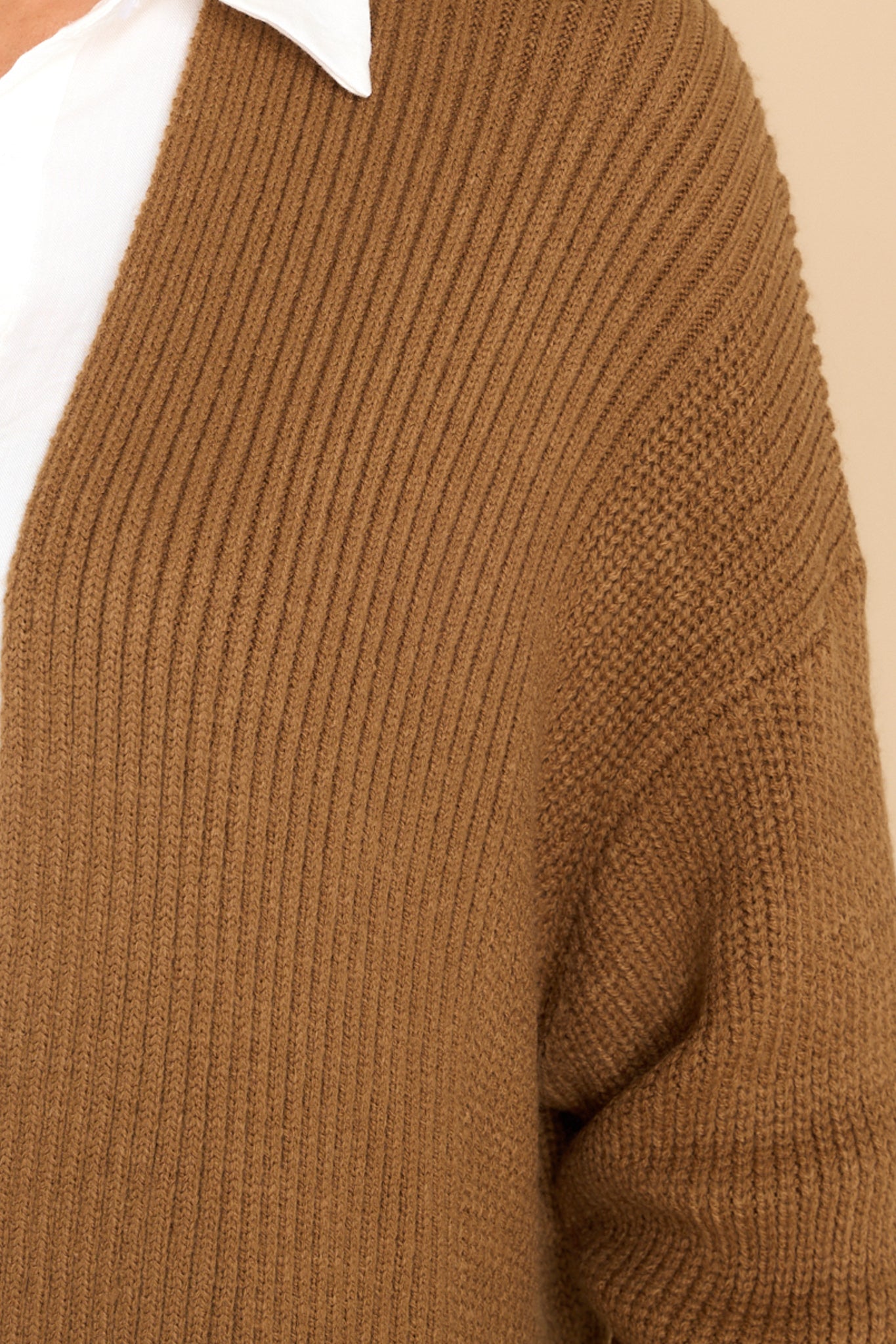 Close up view of this cardigan that features a ribbed design and an open front.