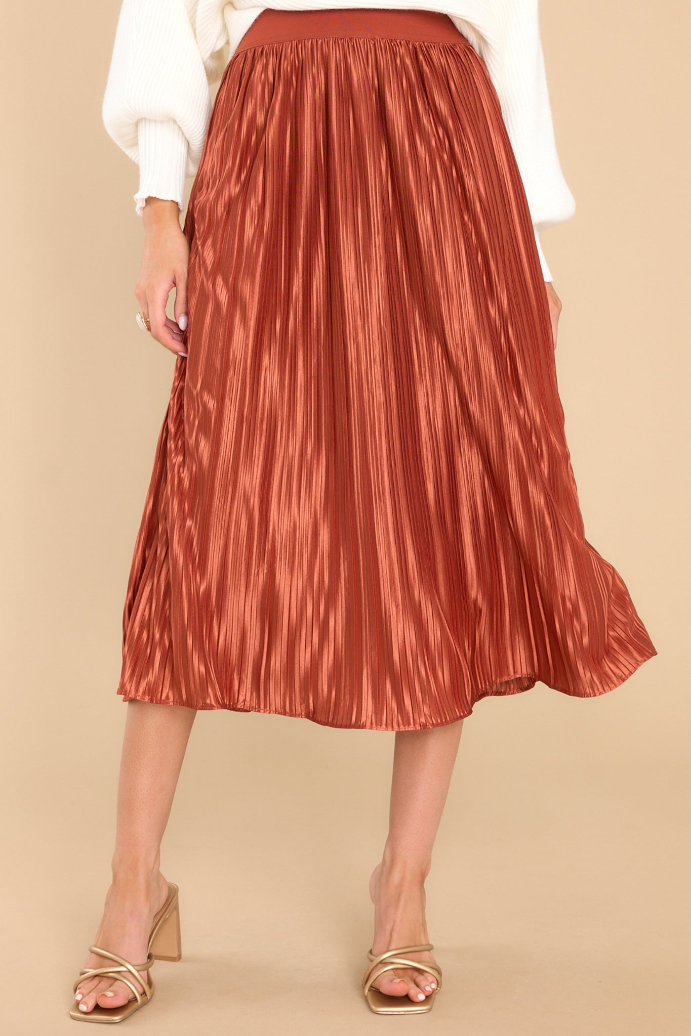 This golden orange skirt features an elastic waistband and a pleated design. 