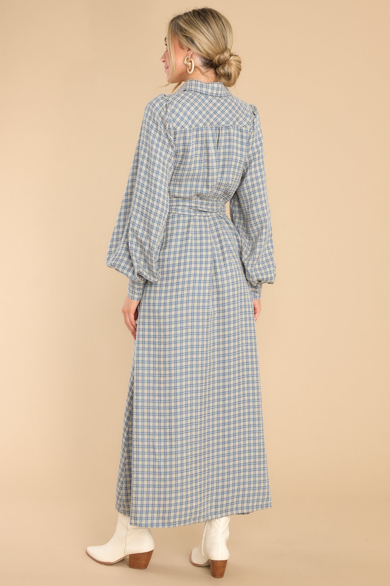 Back view of this dress that features a collared neckline, functional buttons down the front, long sleeves with buttoned cuffs, two functional pockets, and adjustable self-tie belt.