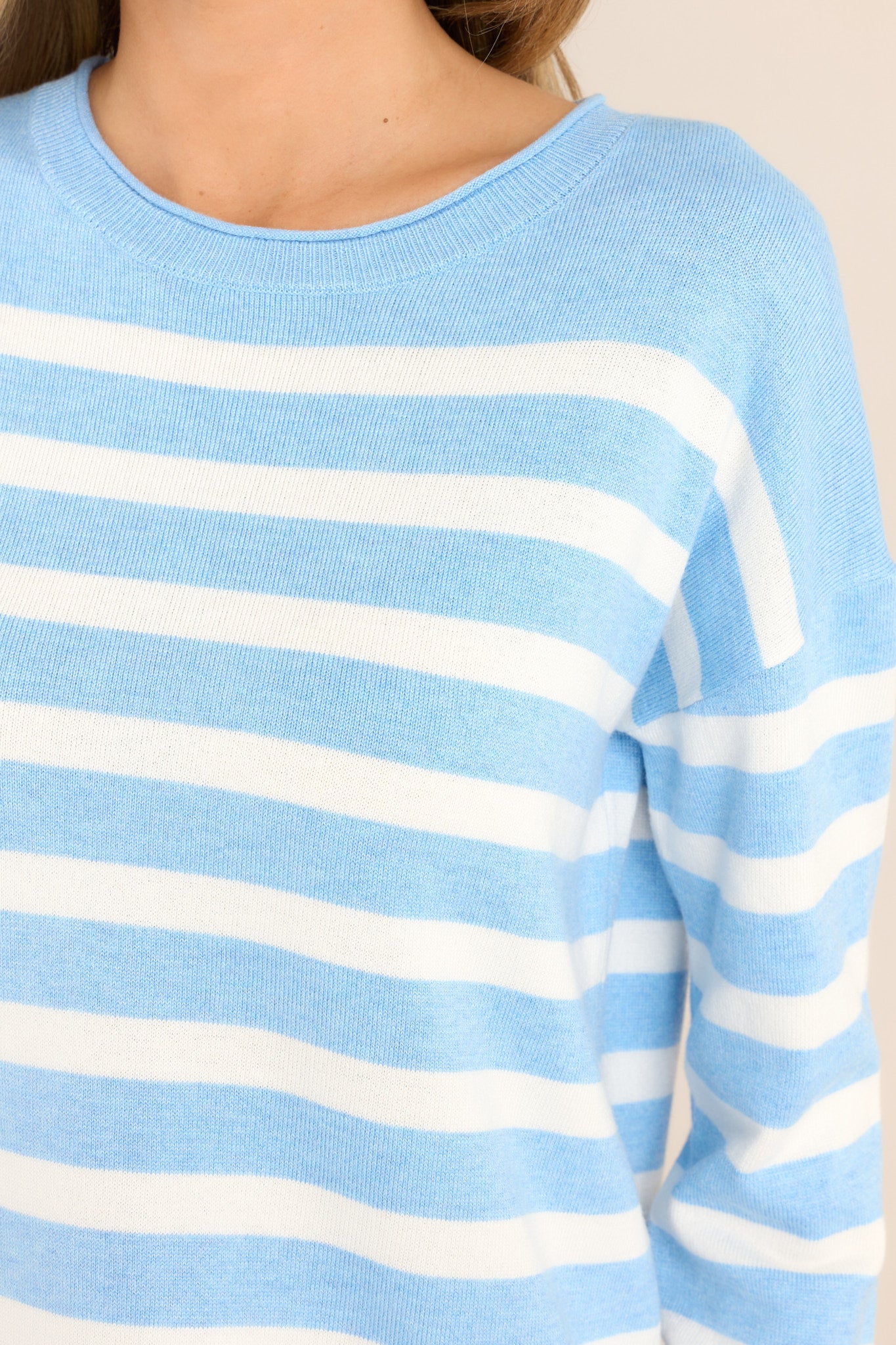 Close up view of this sweater that features a ribbed crew neckline, dropped shoulders, a super soft material, and cuffed long sleeves.