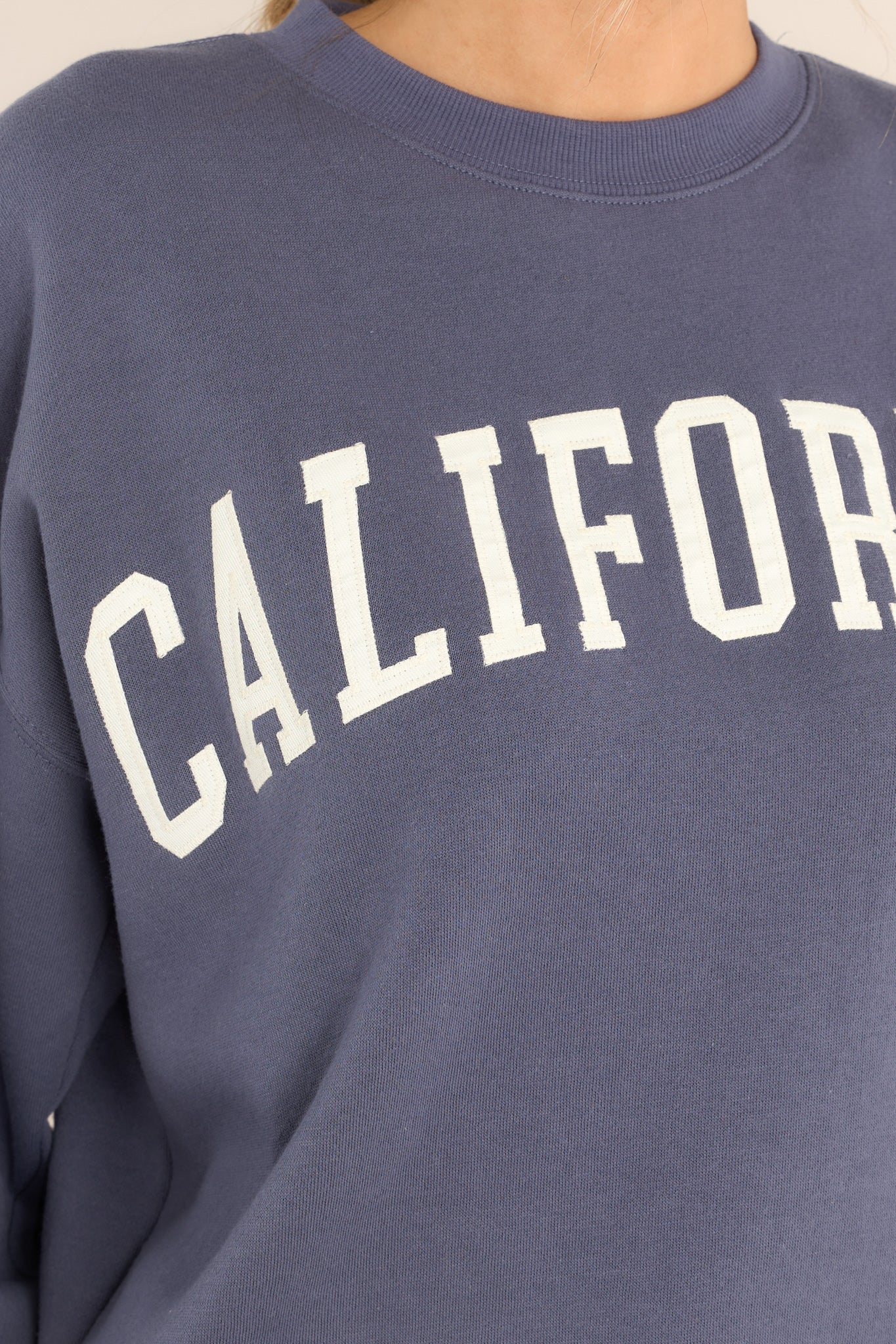 Close up view of this embroidered sweatshirt featuring "California" across the bust.