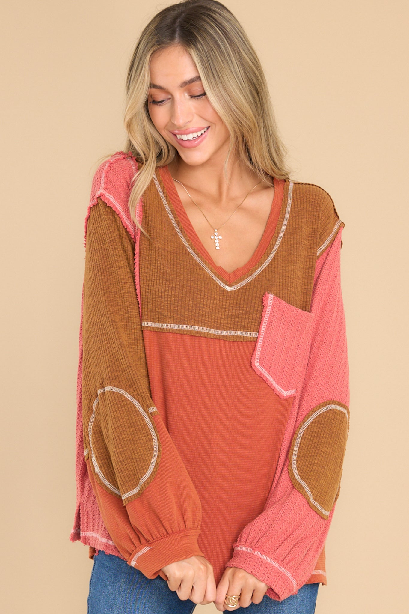 Front view of this top that showcases the patchwork pattern of the fabric in shades of orange, pink, and brown.