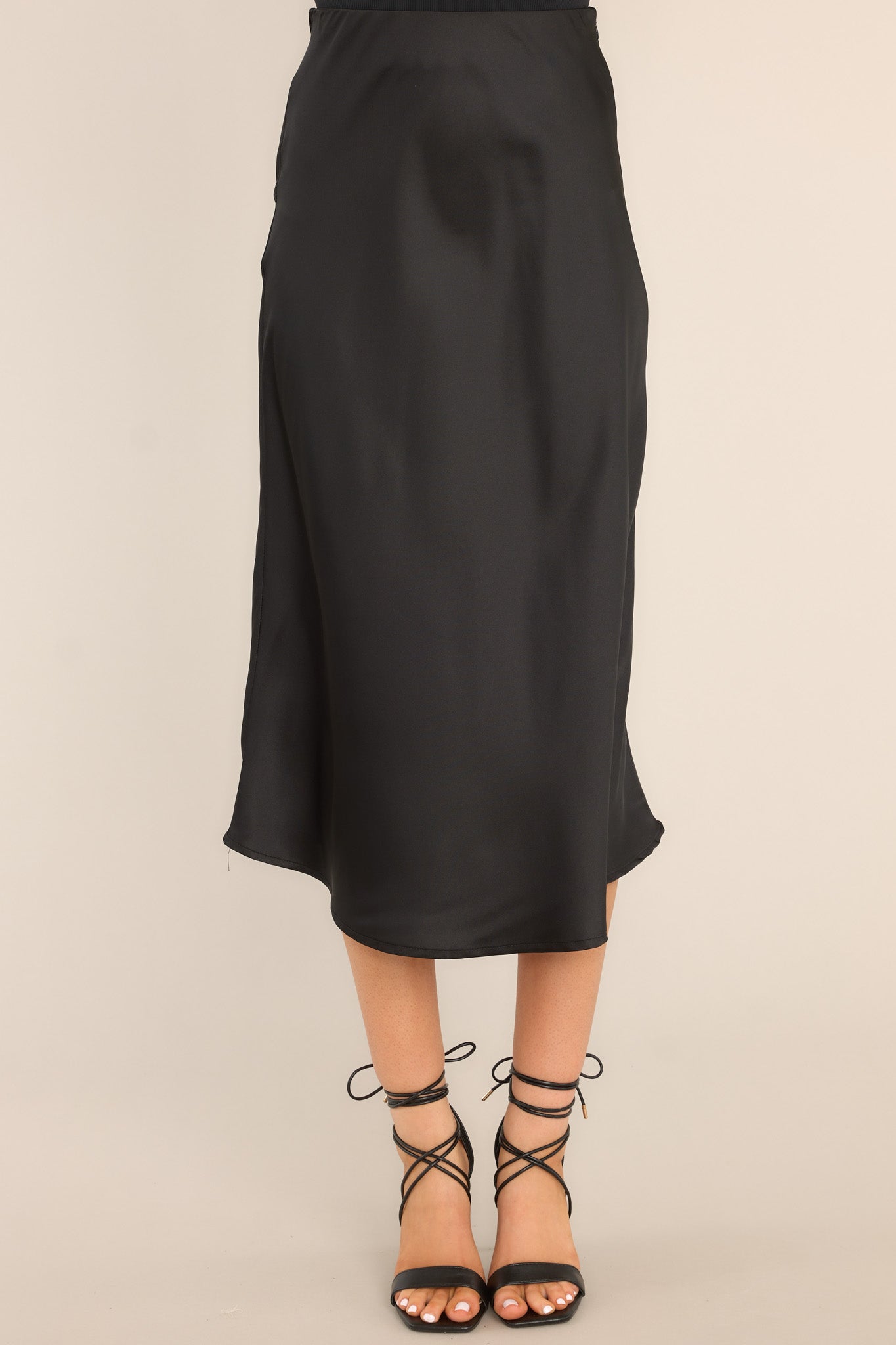 Front view of this skirt that features an elastic waistband, a side zipper closure, a long, flowy skirt, and a satin finish.