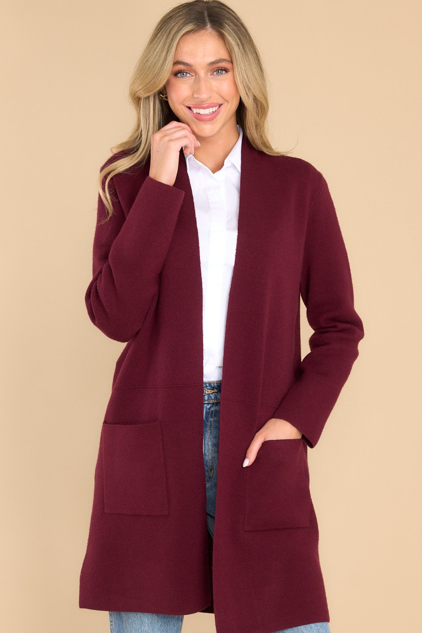 This red wine cardigan features an open front design, two functional pockets, long sleeves, and a soft knit feel throughout.