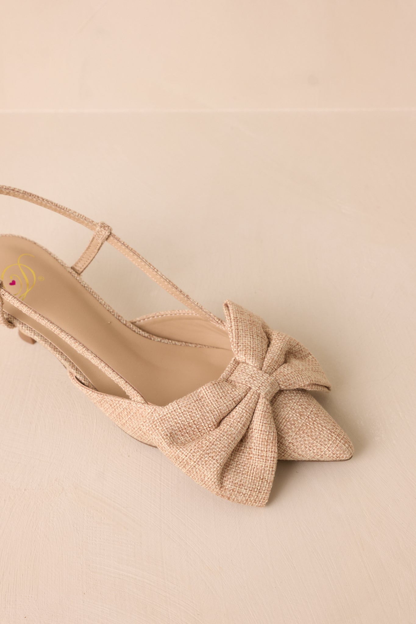 Another detailed view of the raffia bow on the toe, showing its textured fabric and elegant placement.