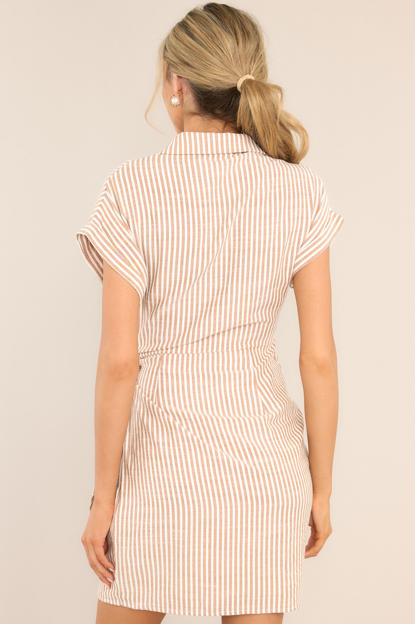 Back view of this dress that features a collared v-neckline and cuffed short sleeves. 