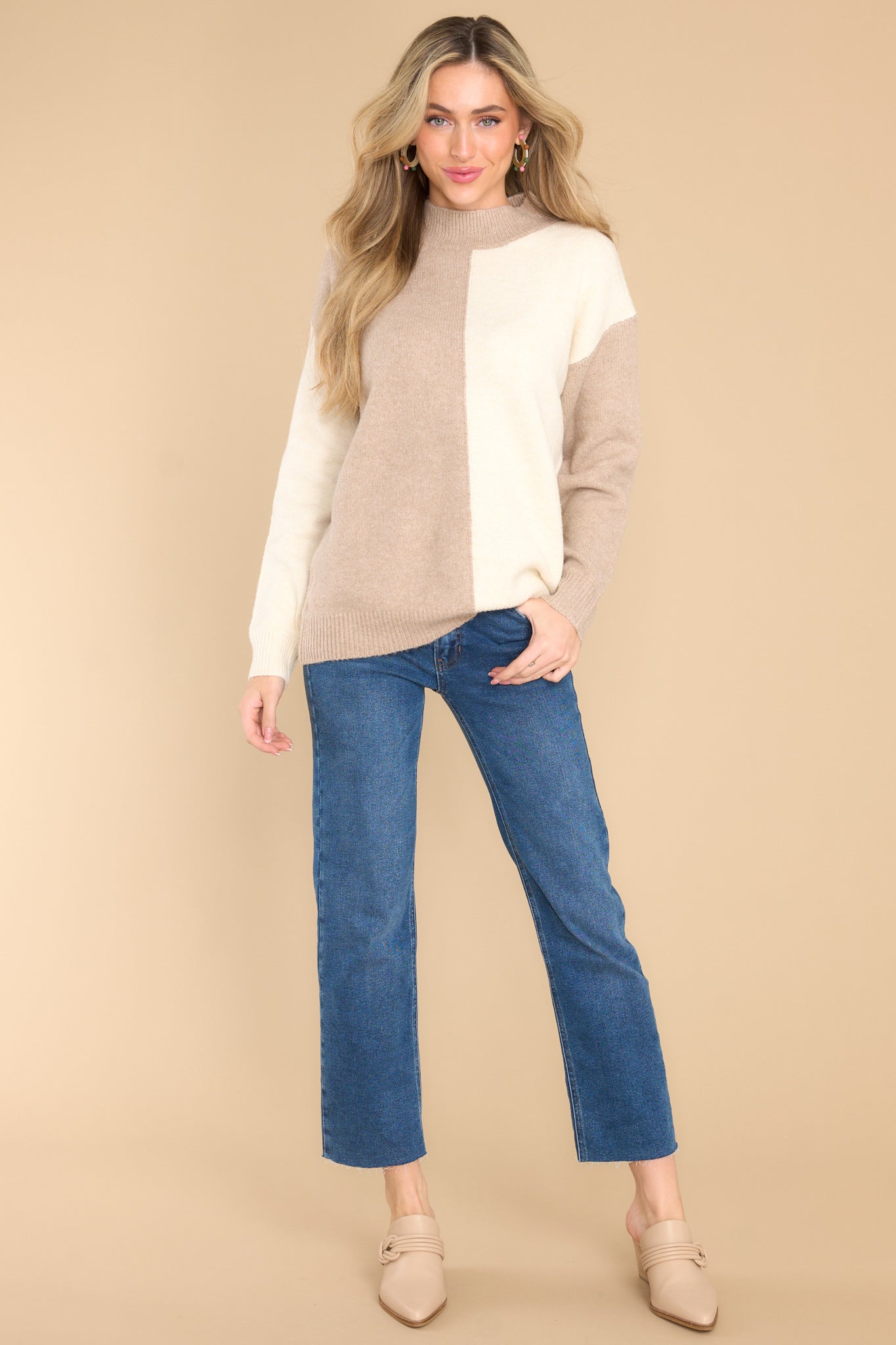 This ivory sweater features a high neckline, a two toned color pattern, and cuffed long sleeves.