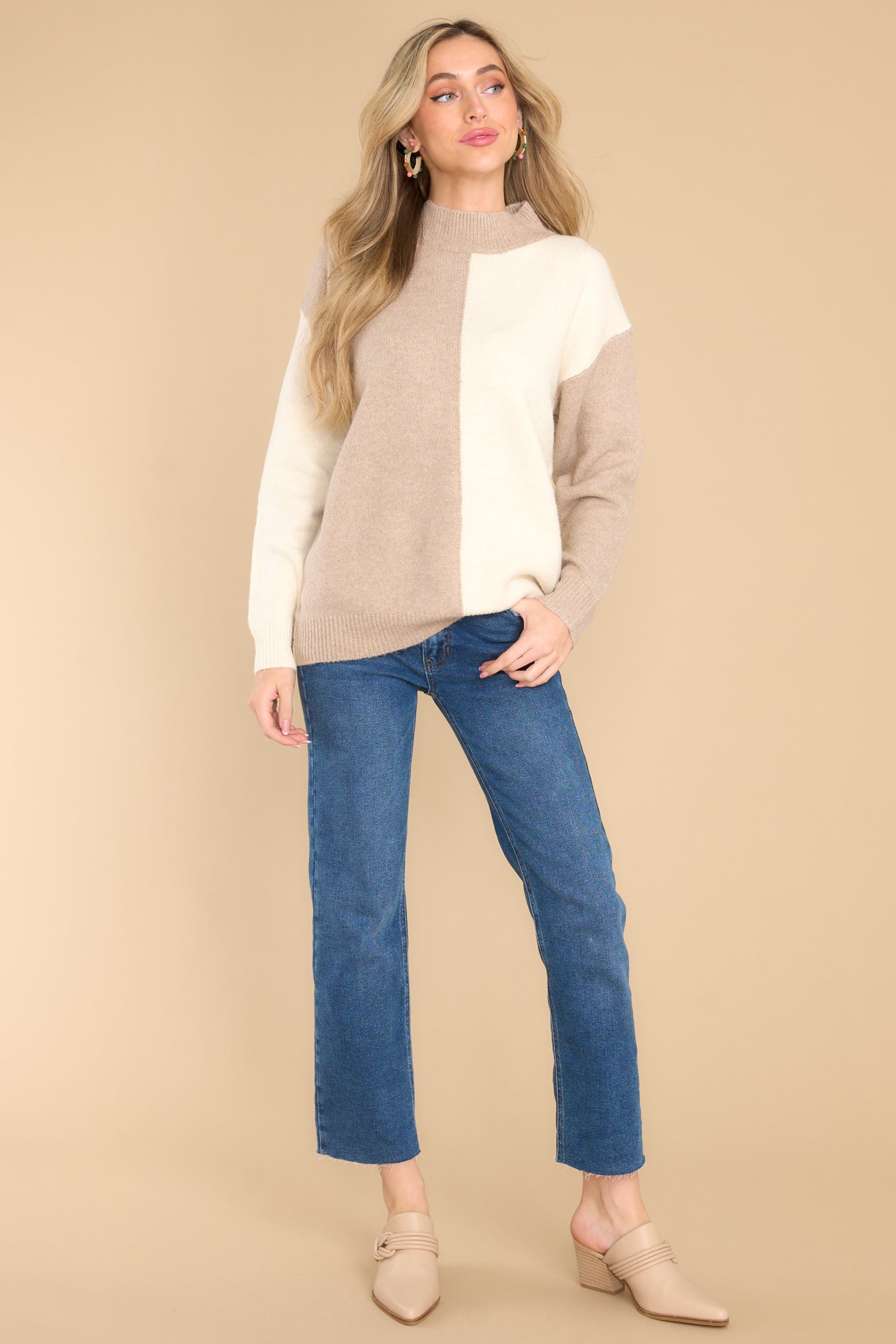 Full body view of this sweater that features a high neckline, a two toned color pattern, and cuffed long sleeves.