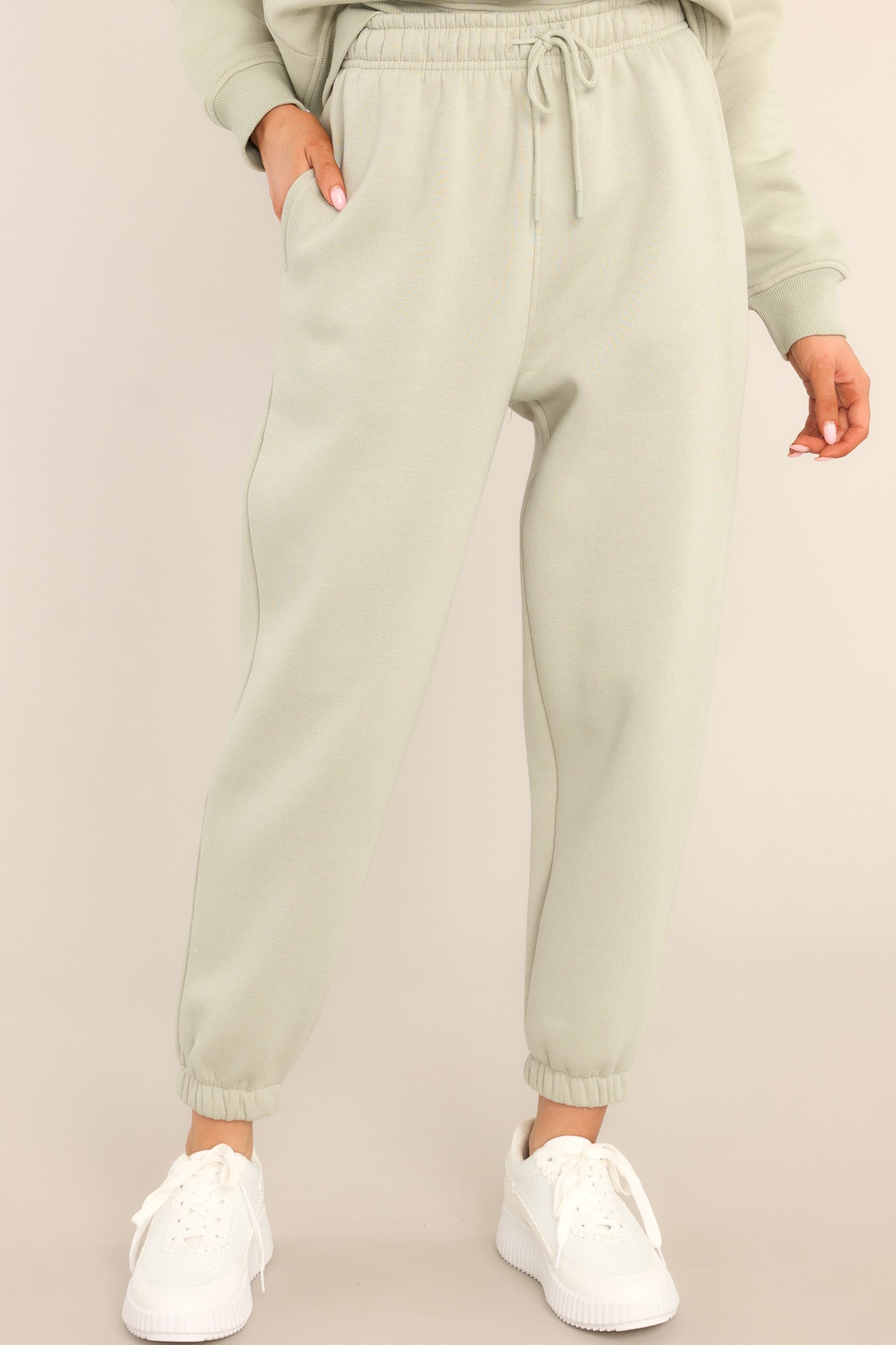 These light green joggers feature a self-tie drawstring waist, pockets, and cuffed elastic ankles.