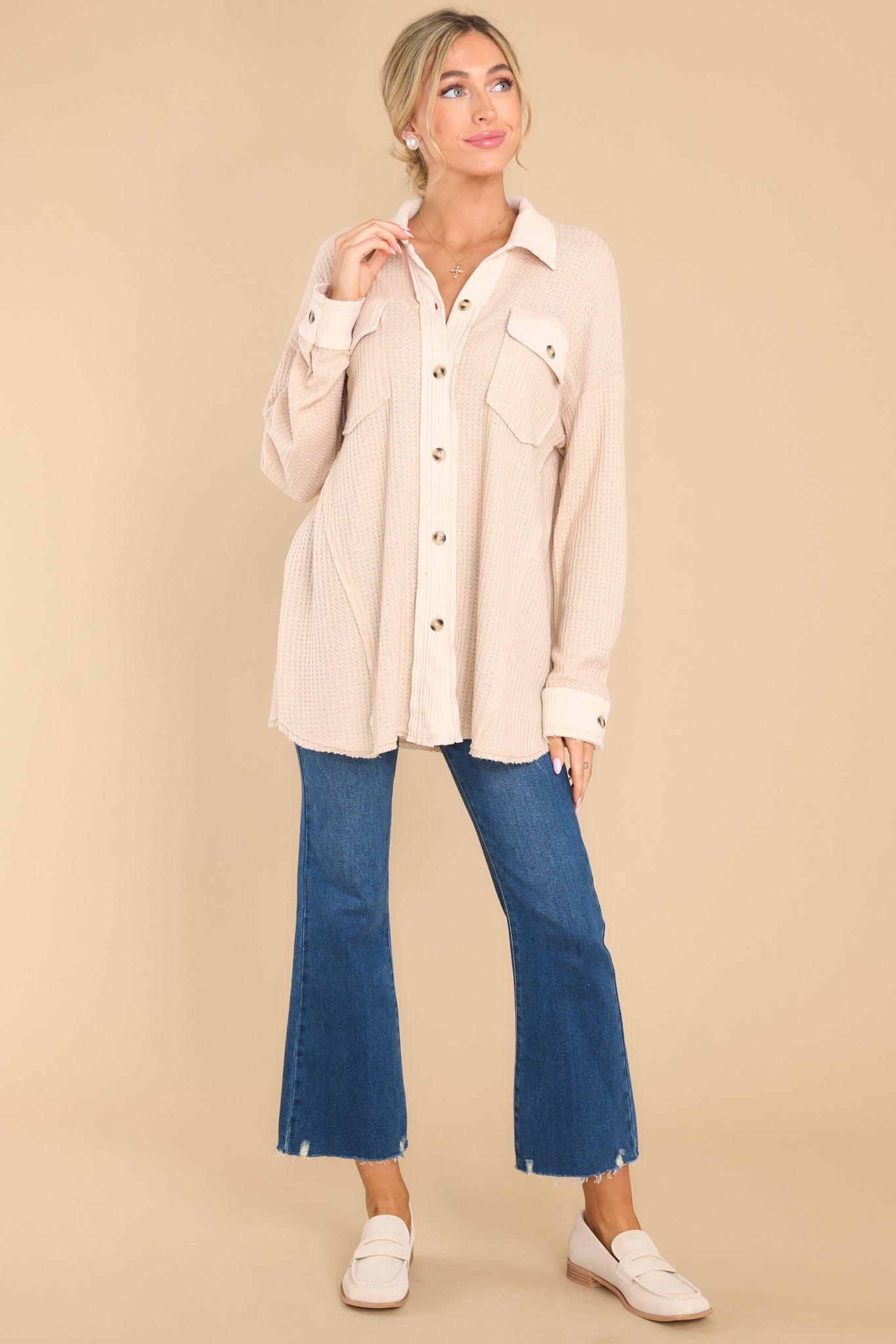 Full body view of this top that features a collared neckline, functional buttons down the front, bust pockets with button closures, long sleeves with buttoned cuffs, and a mixed-textured design throughout.