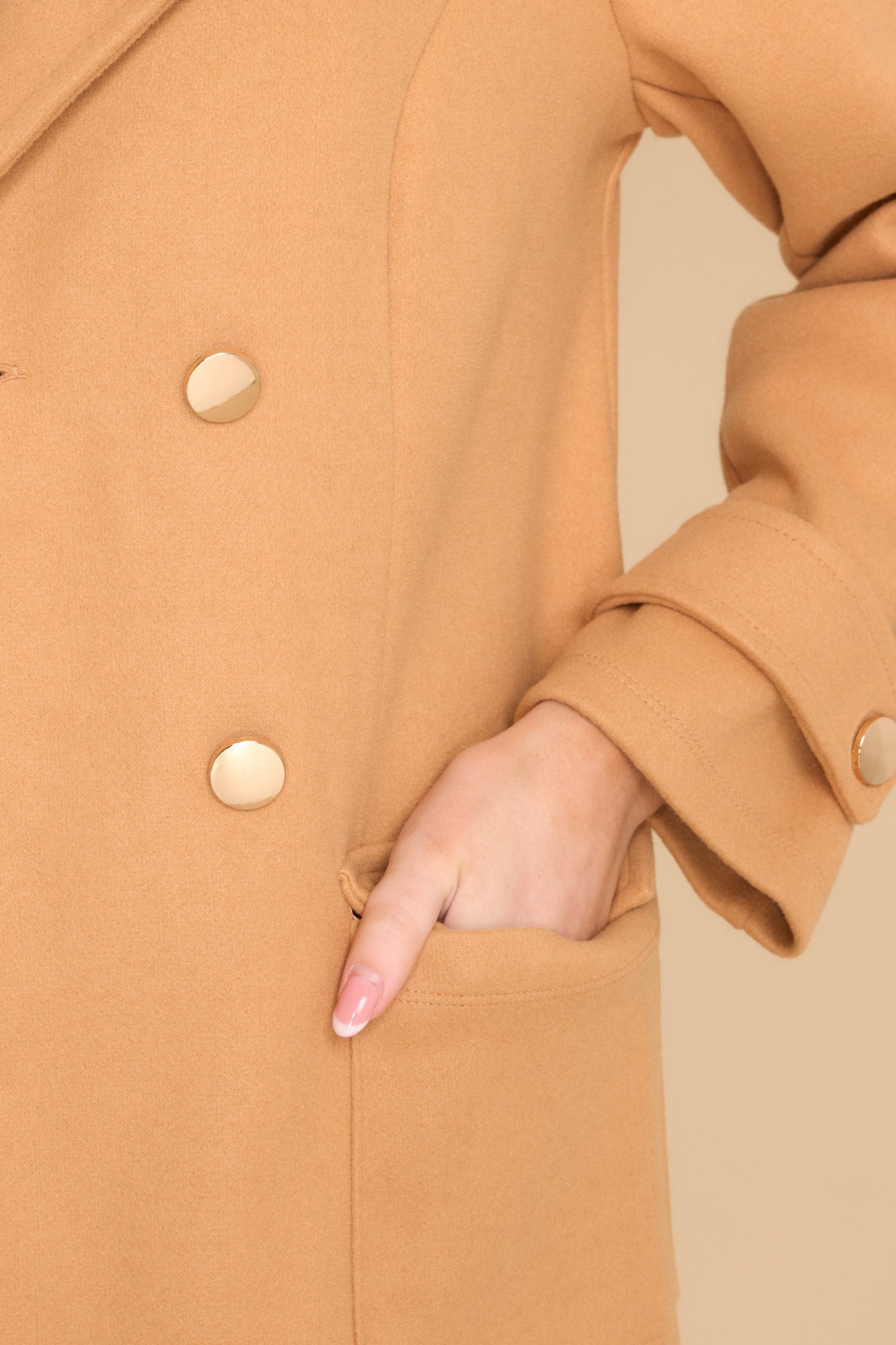 Close up view of this coat that features functional buttons and pockets.