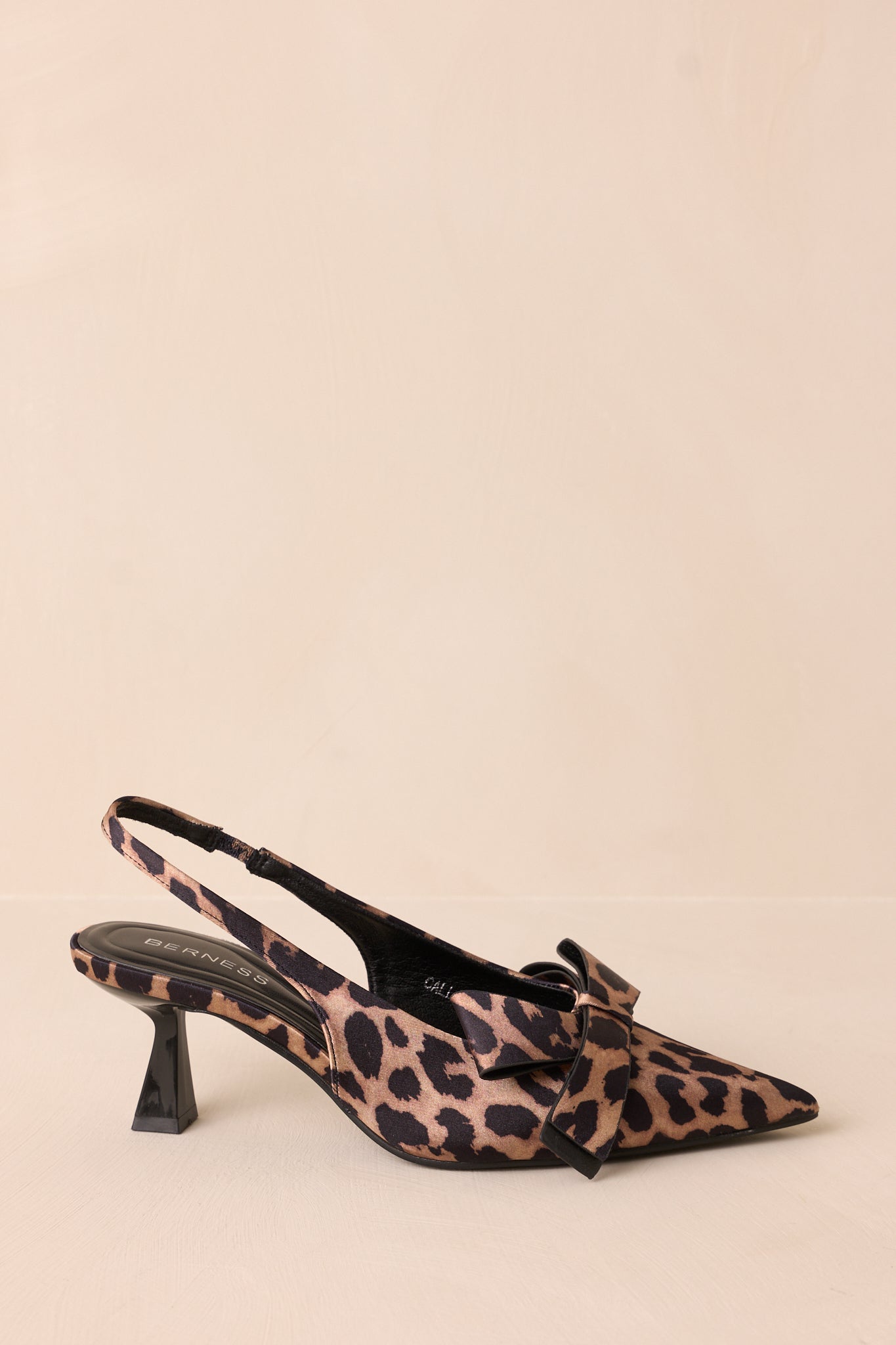 A side view of the leopard heels, emphasizing the slingback strap that adds a chic touch while ensuring a secure fit.