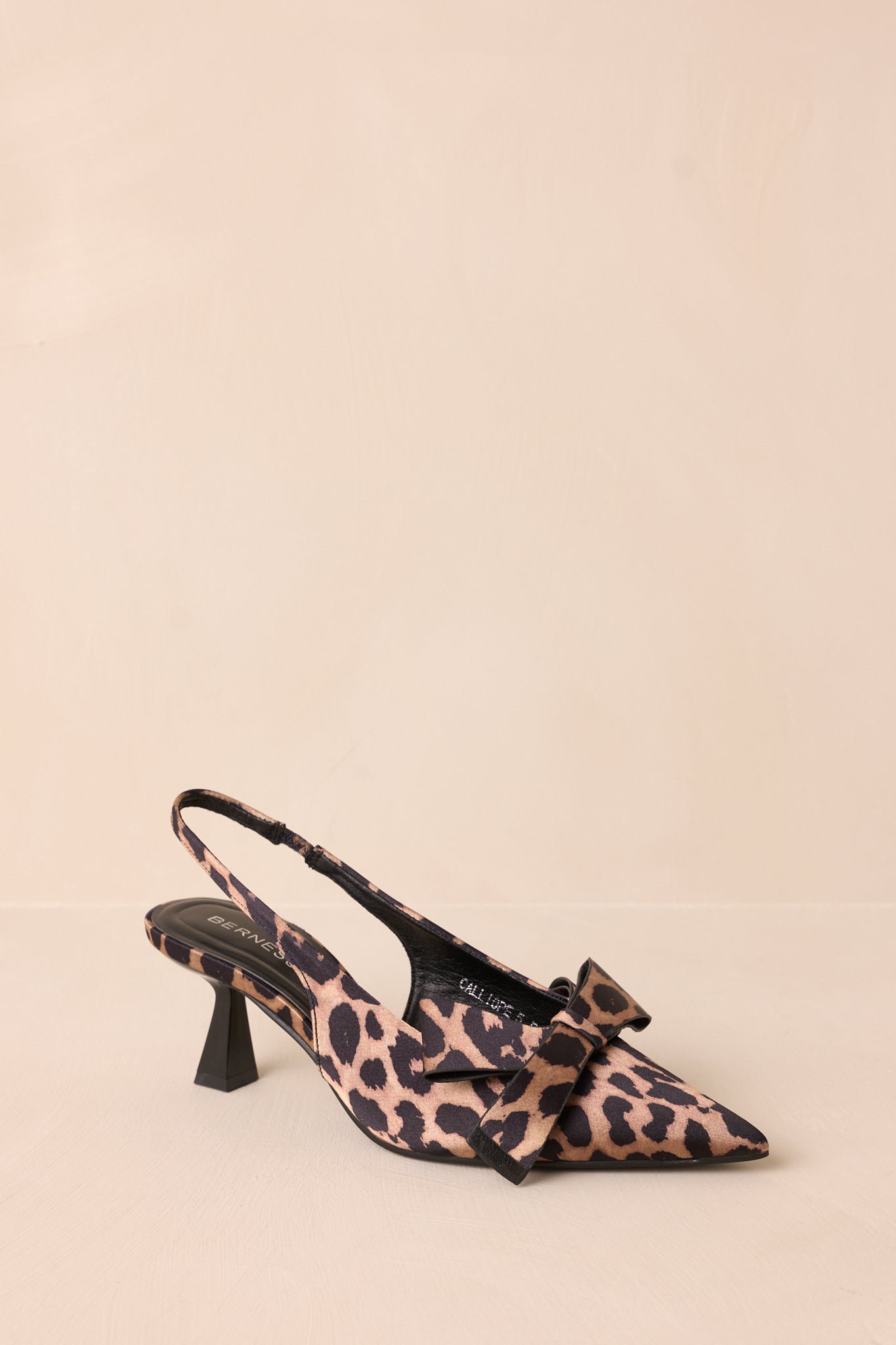 A cropped view of the leopard heels showcasing the pointed toe design and the elegant bow detail at the front, highlighting their stylish appeal.