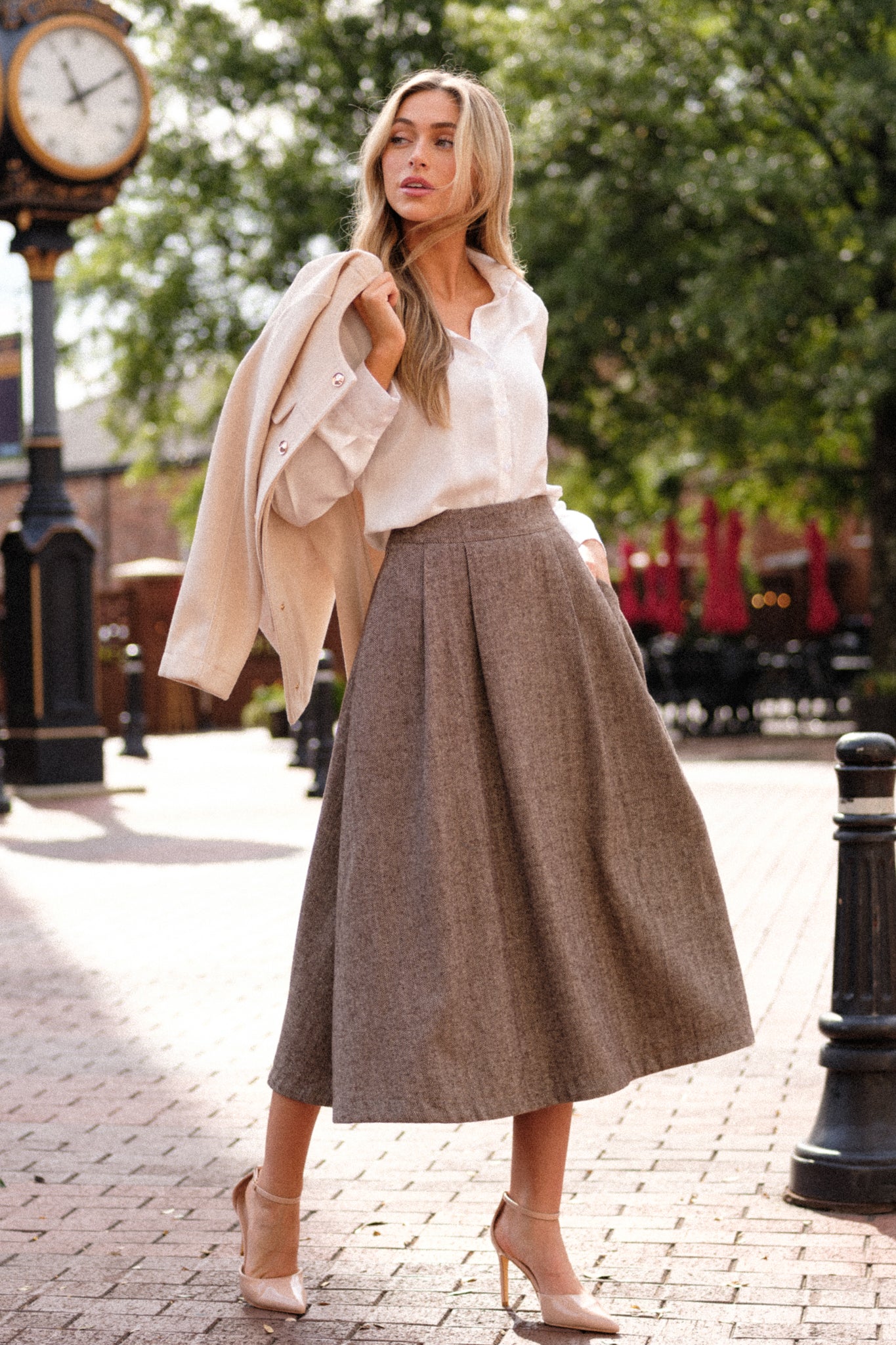 A full-length view of the brown midi skirt, showcasing the herringbone print and its flattering silhouette as it falls just below the knee.