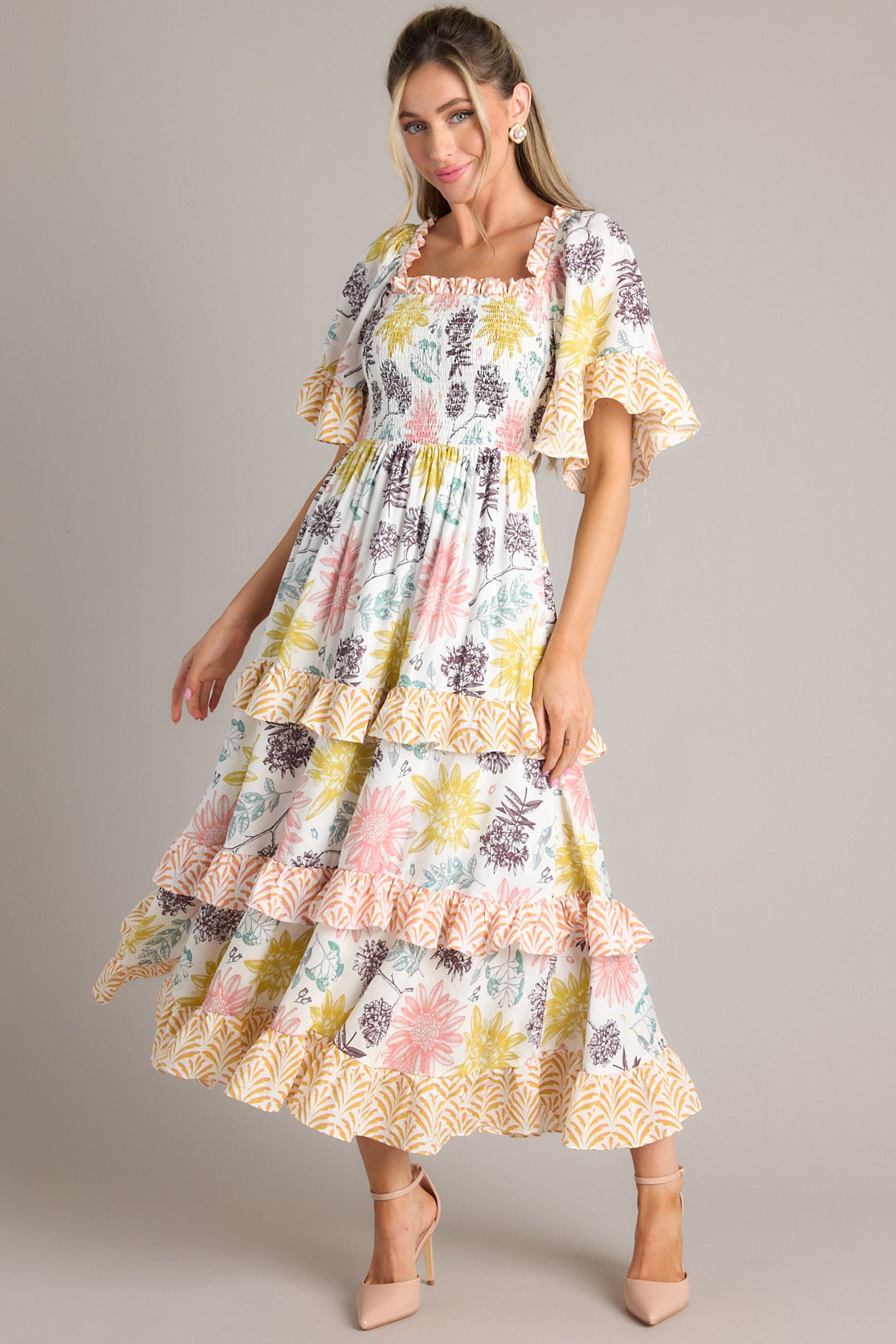 Front view of this dress that features a square neckline, butterfly sleeves, a fully smocked bust, and a long, flowy skirt.