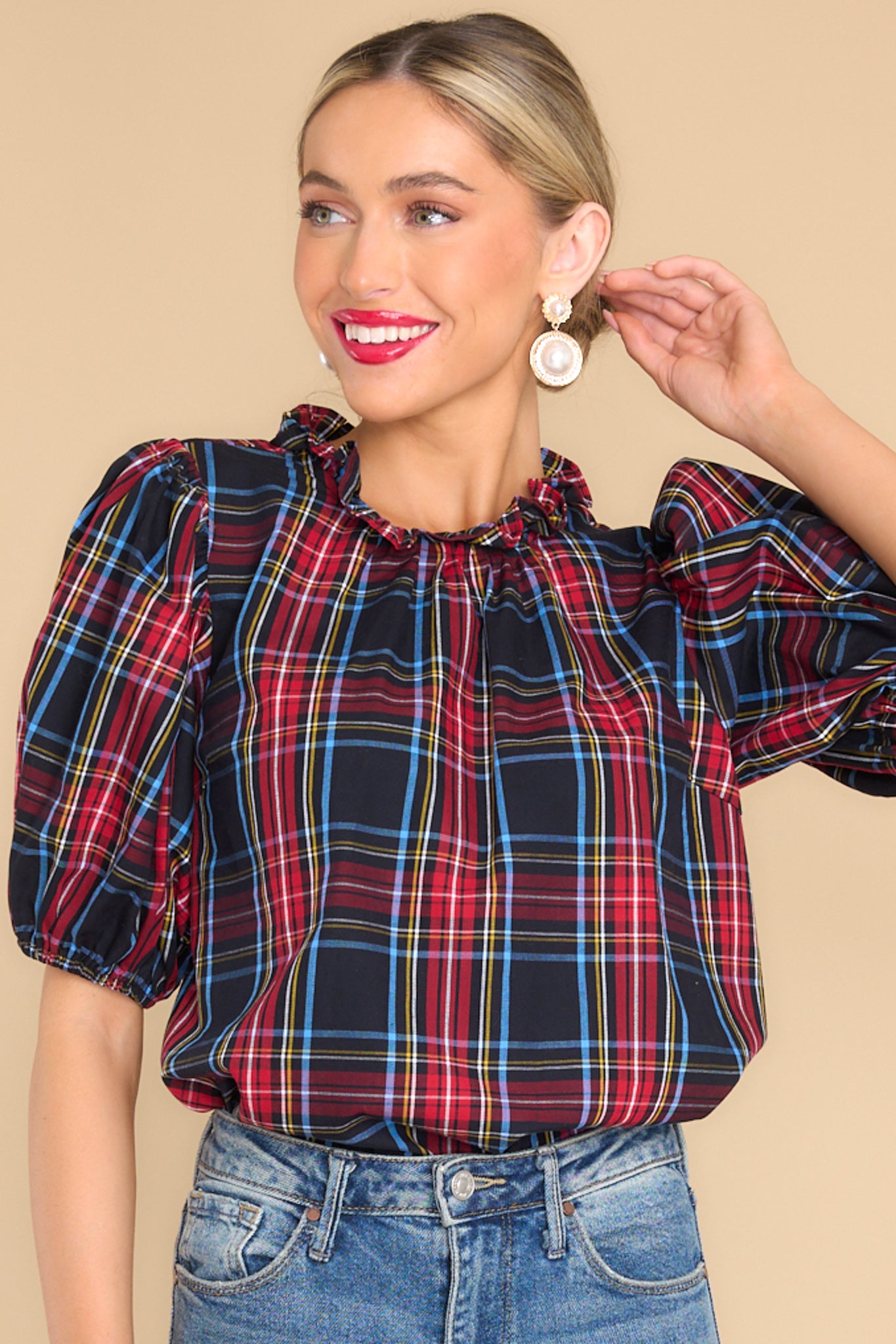 Front view of this top that features a ruffled neckline, a keyhole closure in the back, elastic cuffed puffy sleeves, and a plaid pattern.