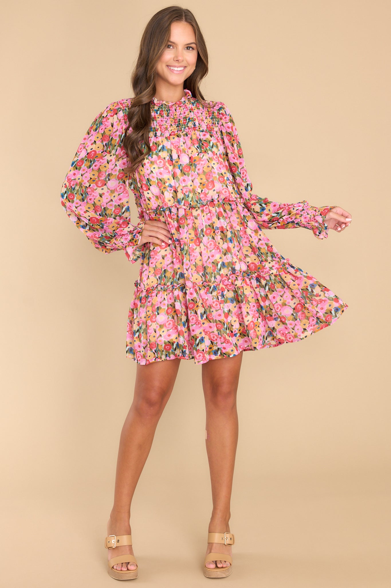 Full body view of this dress that features a high neckline, a keyhole cutout at the back of the neck with a button closure, a sheer smocked section at the shoulders, sheer long sleeves with smocked cuffs, and a flowy skirt.