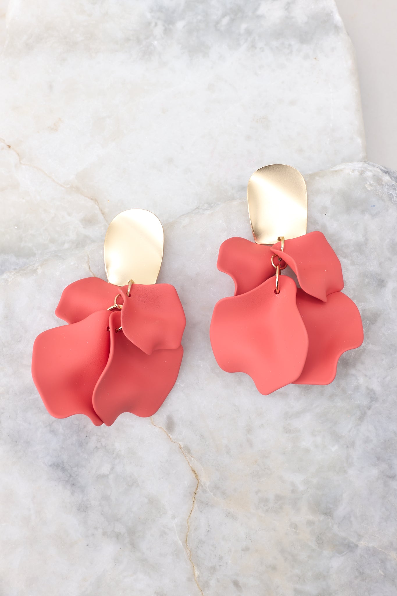 These earrings feature a hammered gold stud with coral petal shaped dangles, and a secure post backing.