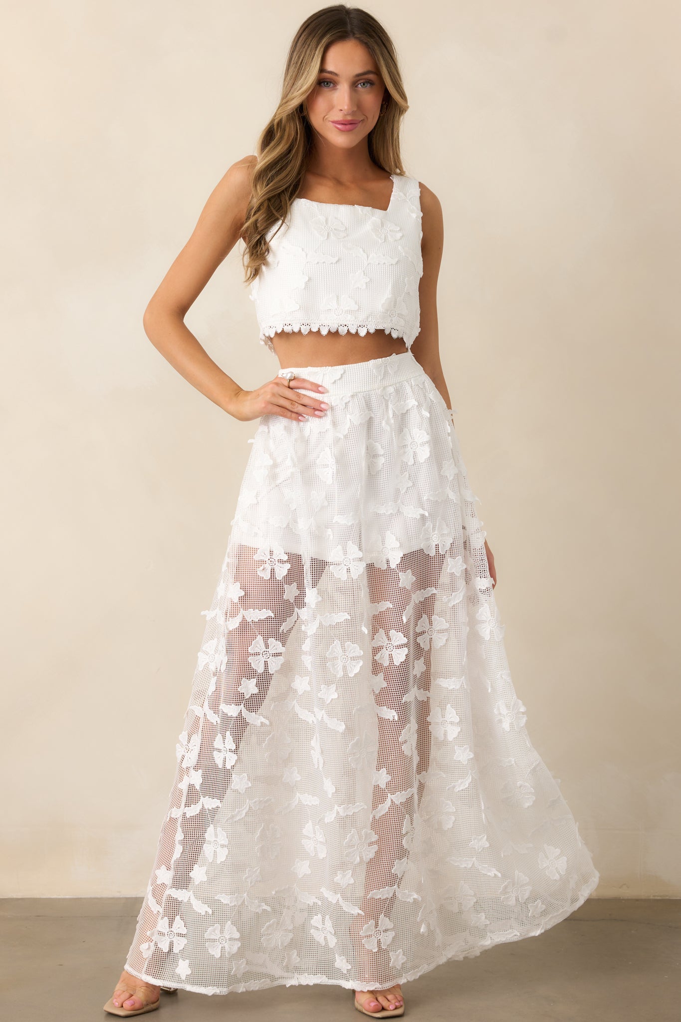 Elegant and airy, this white midi skirt features a mini-length underlay with a flowing embroidered midi overlay.