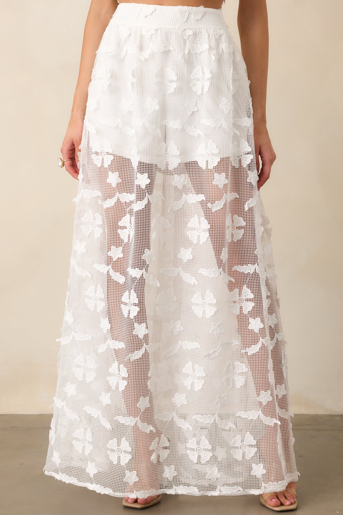 The delicate floral embroidery adds texture and charm to this high-waisted white midi skirt.