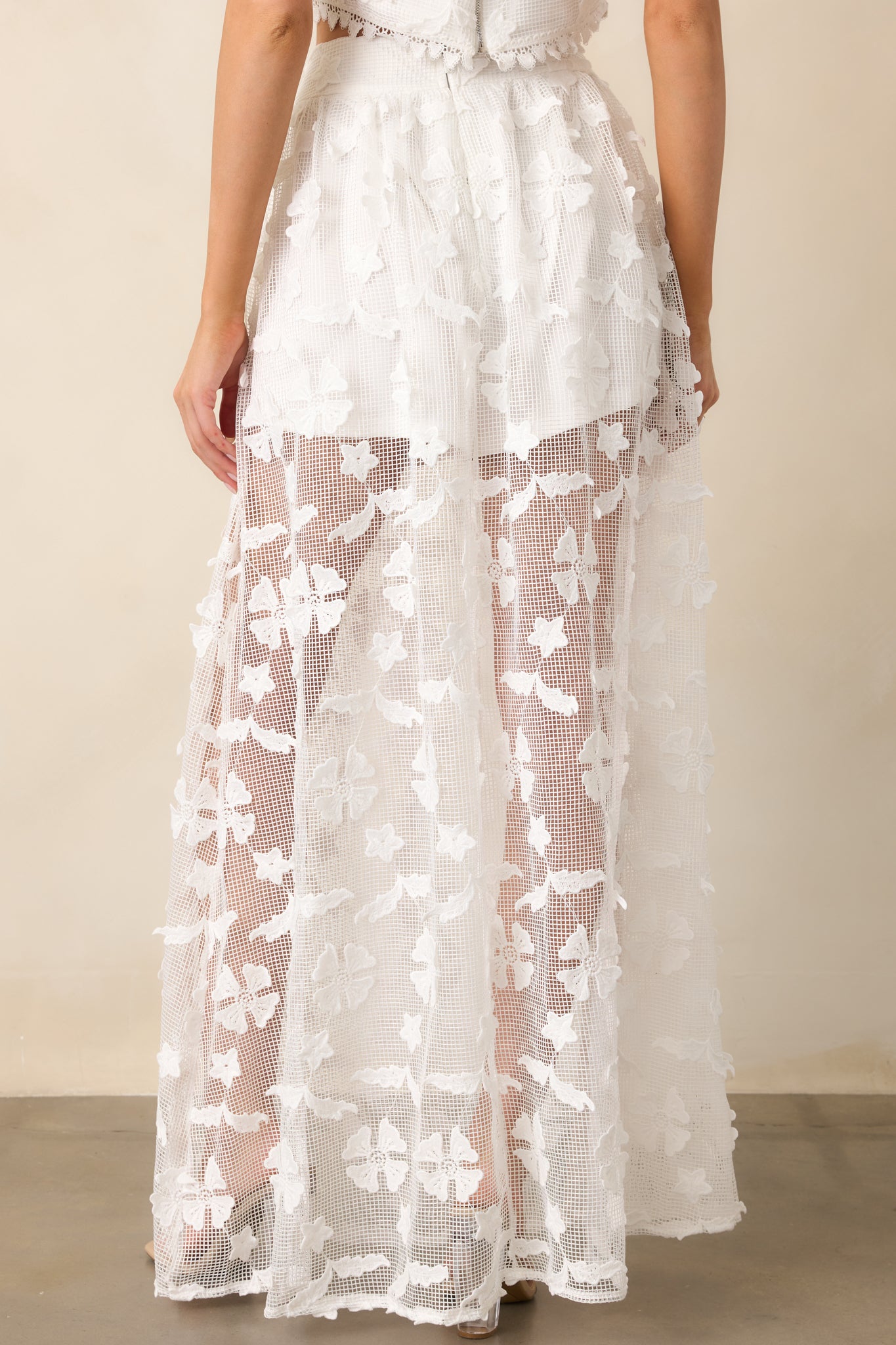 The back of this white midi skirt highlights the layered construction and graceful drape of the fabric.