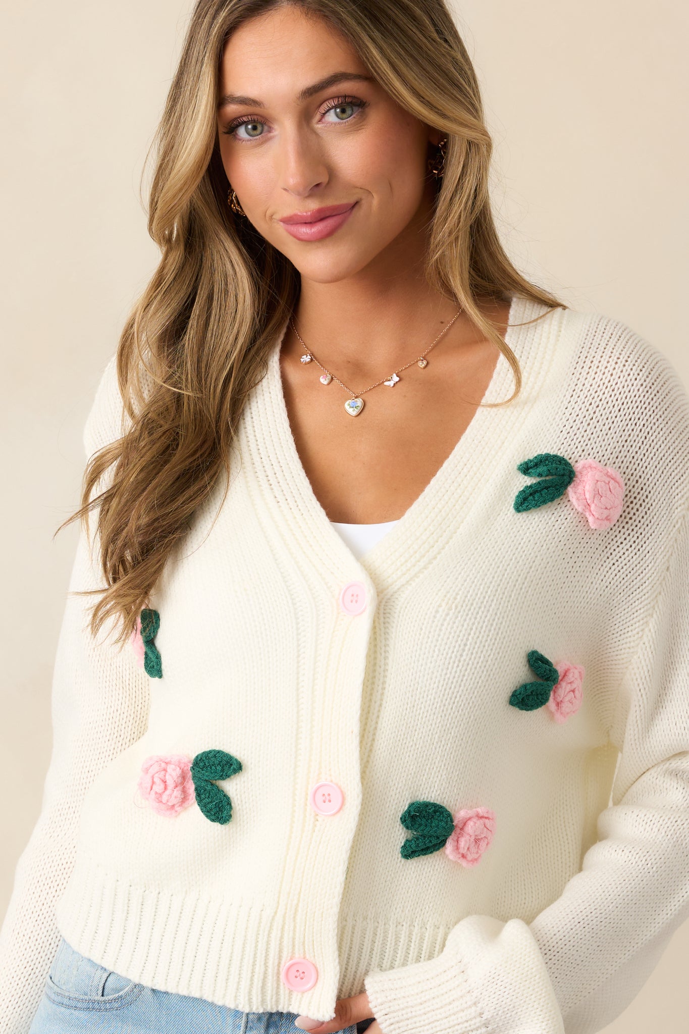 The crochet rose appliques bring a vintage-inspired, handcrafted feel to this classic ivory cardigan