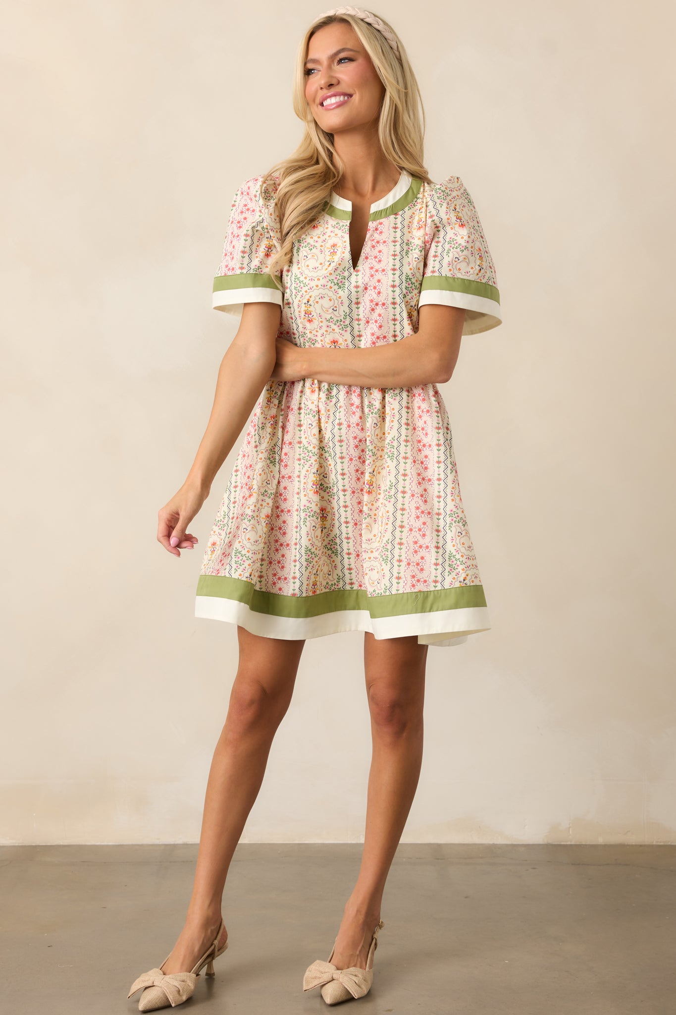 A charming green mini dress with a ditsy floral print, rounded notch neckline, and a relaxed, easygoing fit.