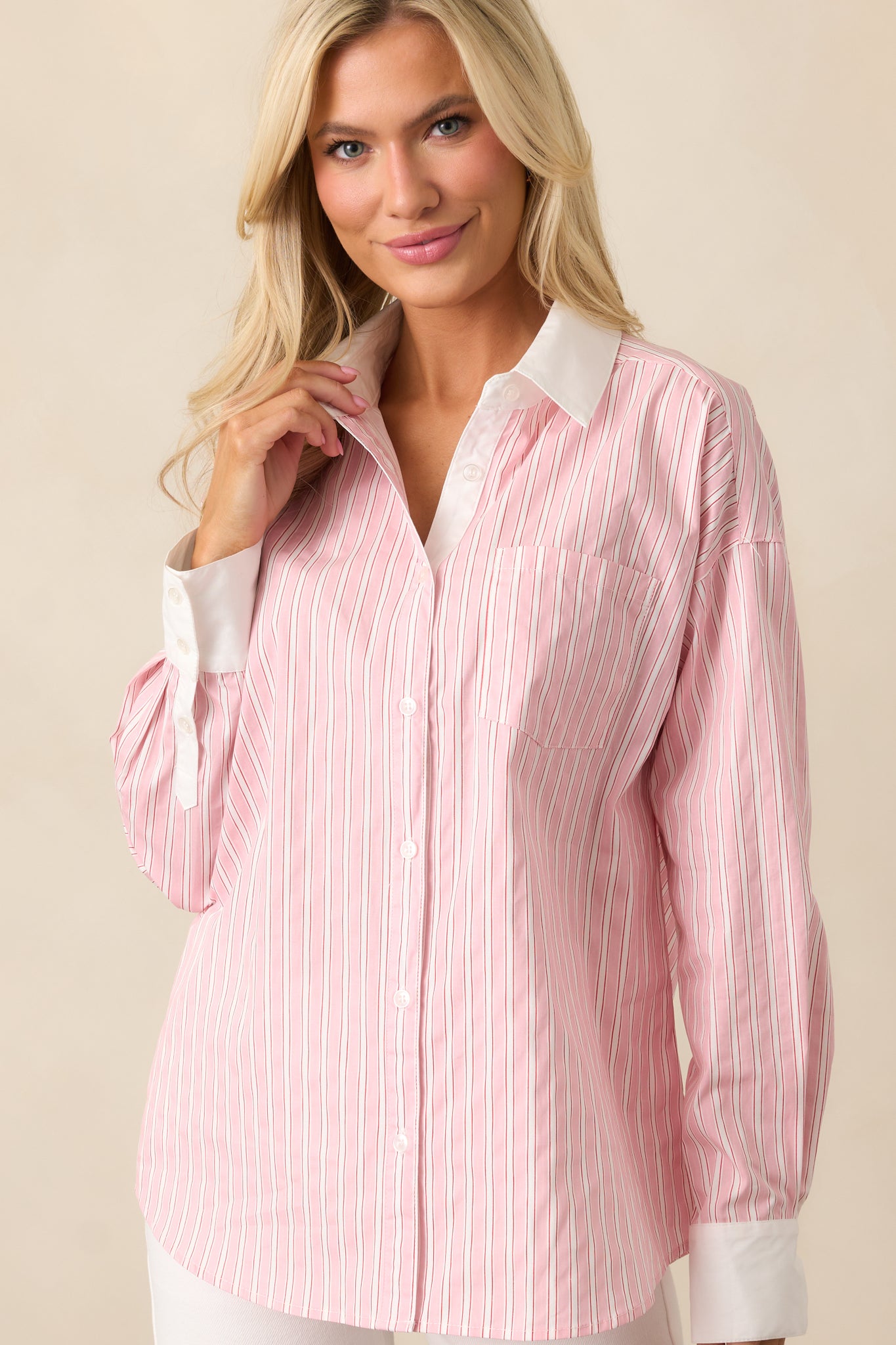 A closer look at the white collared neckline and button front, adding structure to this soft pink blouse.