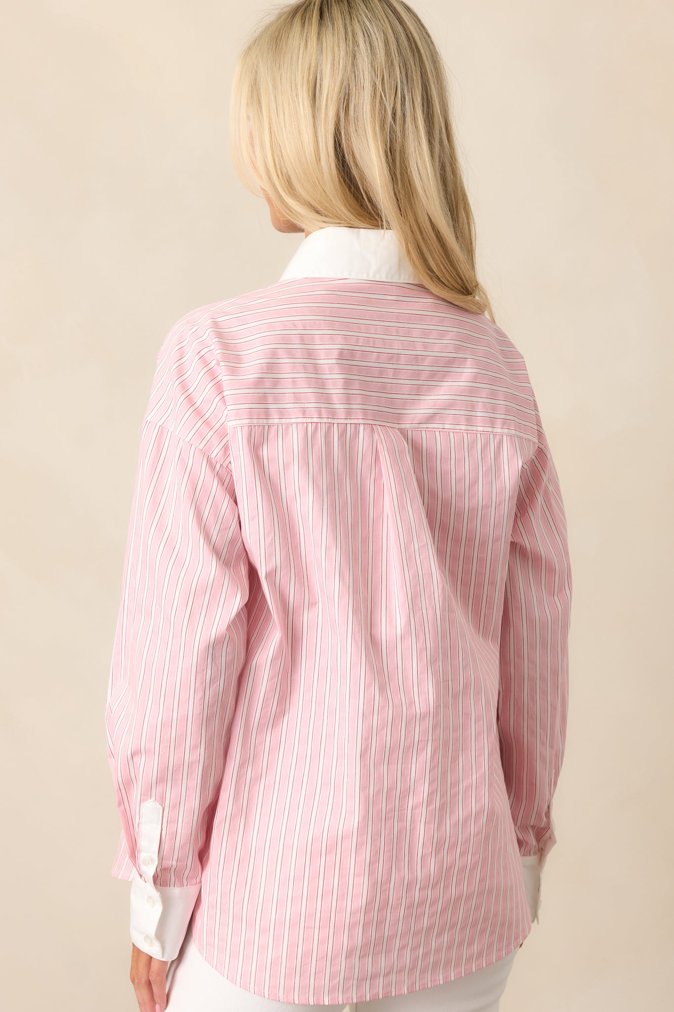 The back of this pink blouse offers a simple, clean design with a relaxed fit and subtle stripe pattern.