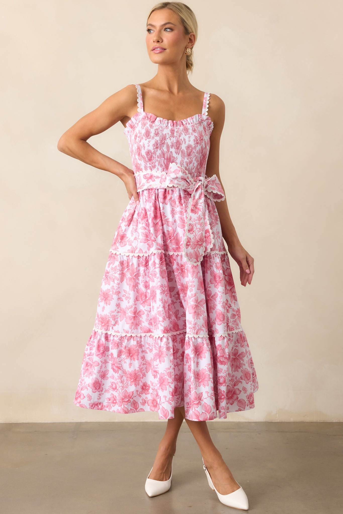 A floral dress with a pink floral print, ric rac detailing, and a fully smocked bust for a charming, textured look.