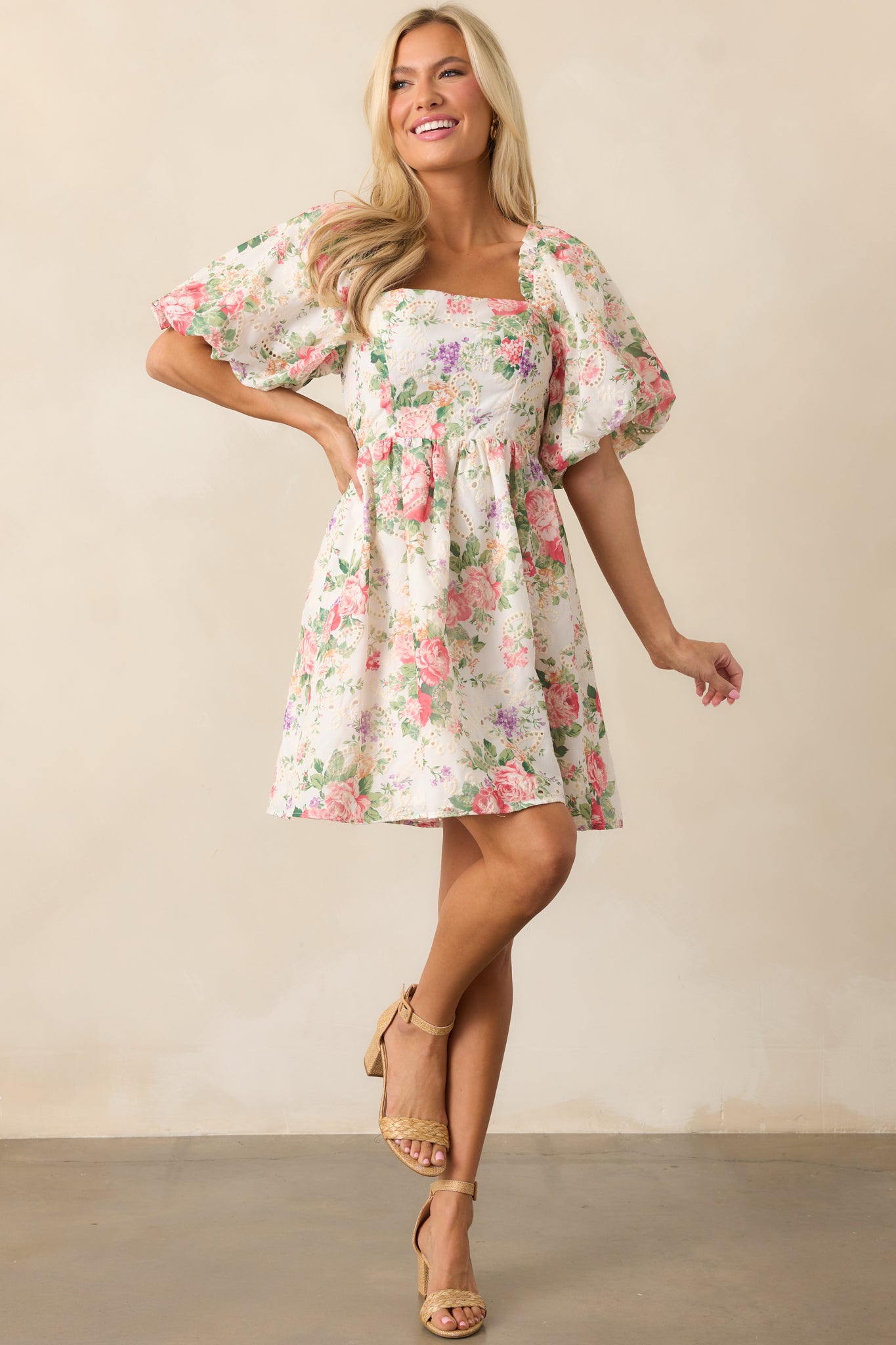 A breezy green mini dress with puff sleeves, a smocked back, and a delicate floral pattern.