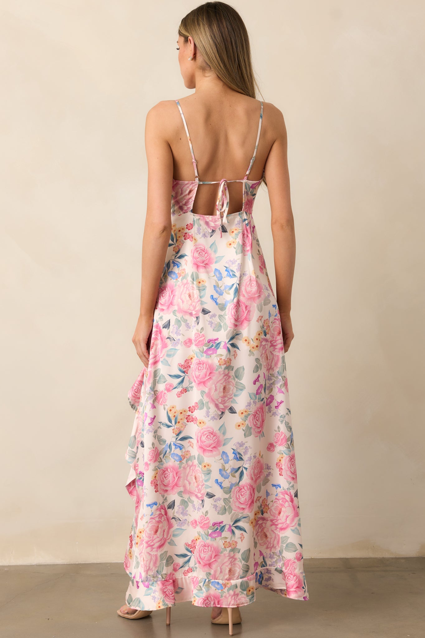 The back of this pink multi maxi dress offers a simple, clean finish with adjustable straps for a personalized fit, while maintaining the elegant flow of the fabric.