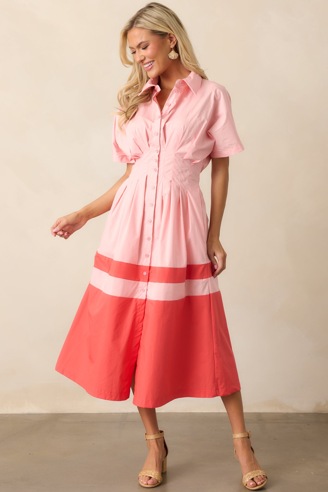 A front-facing view of the pink midi dress showcasing the collared neckline, button front design, and elastic waistband.