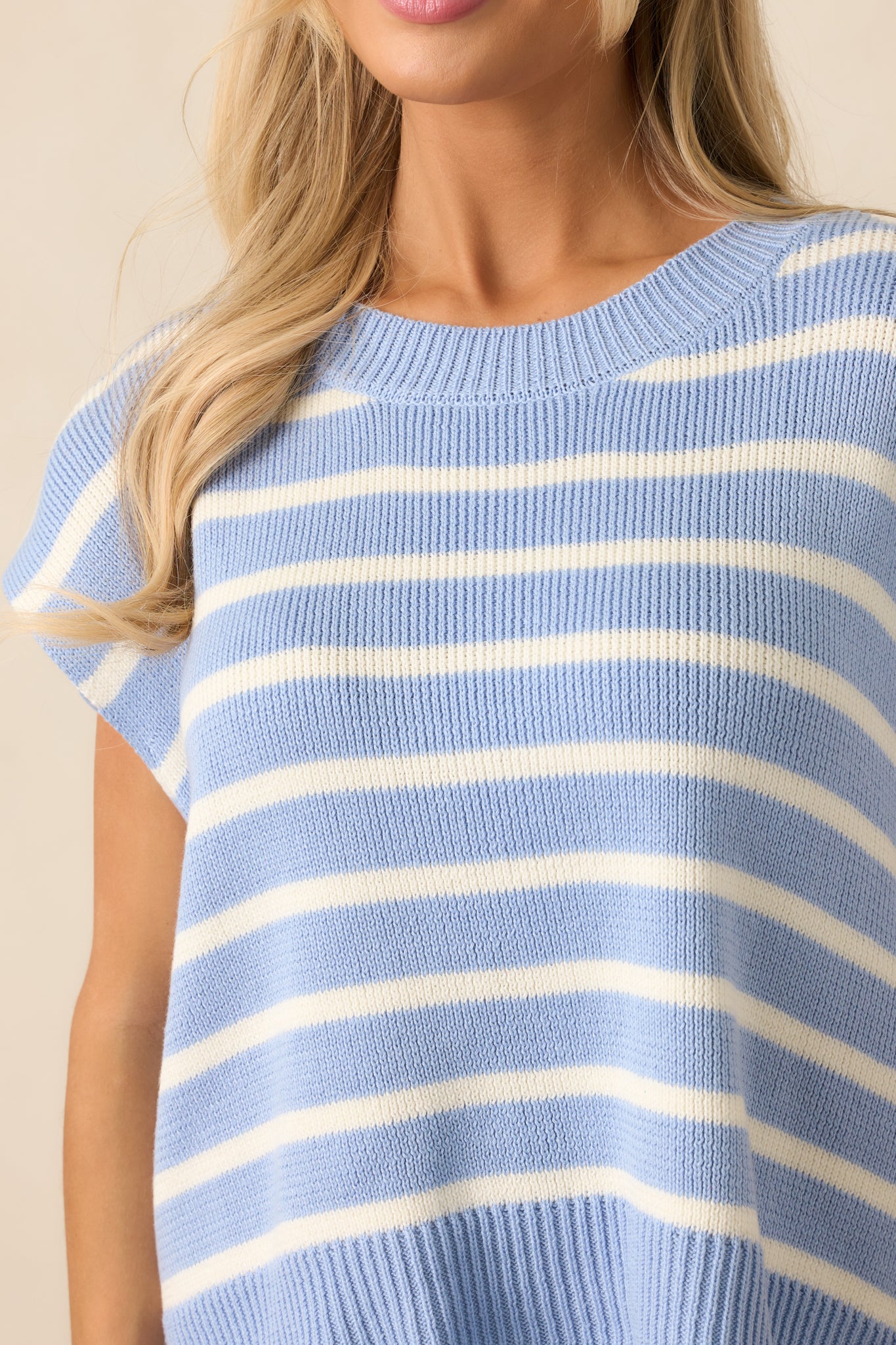 Close-up of the light blue sweater top’s ribbed crew neckline and horizontal stripes, with a focus on the textured fabric and seamless design.