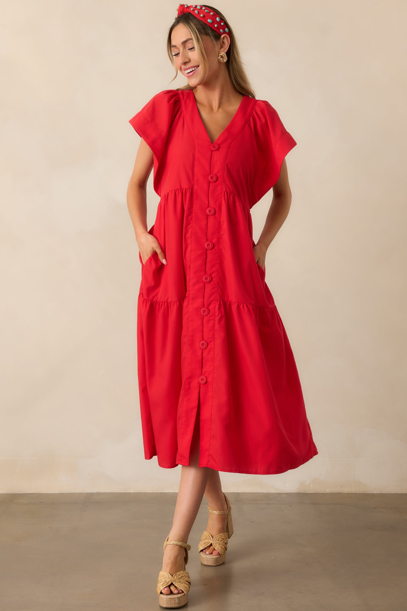 A complete look of the red midi dress highlighting its flowy tiered skirt, short sleeves, and vibrant red fabric.