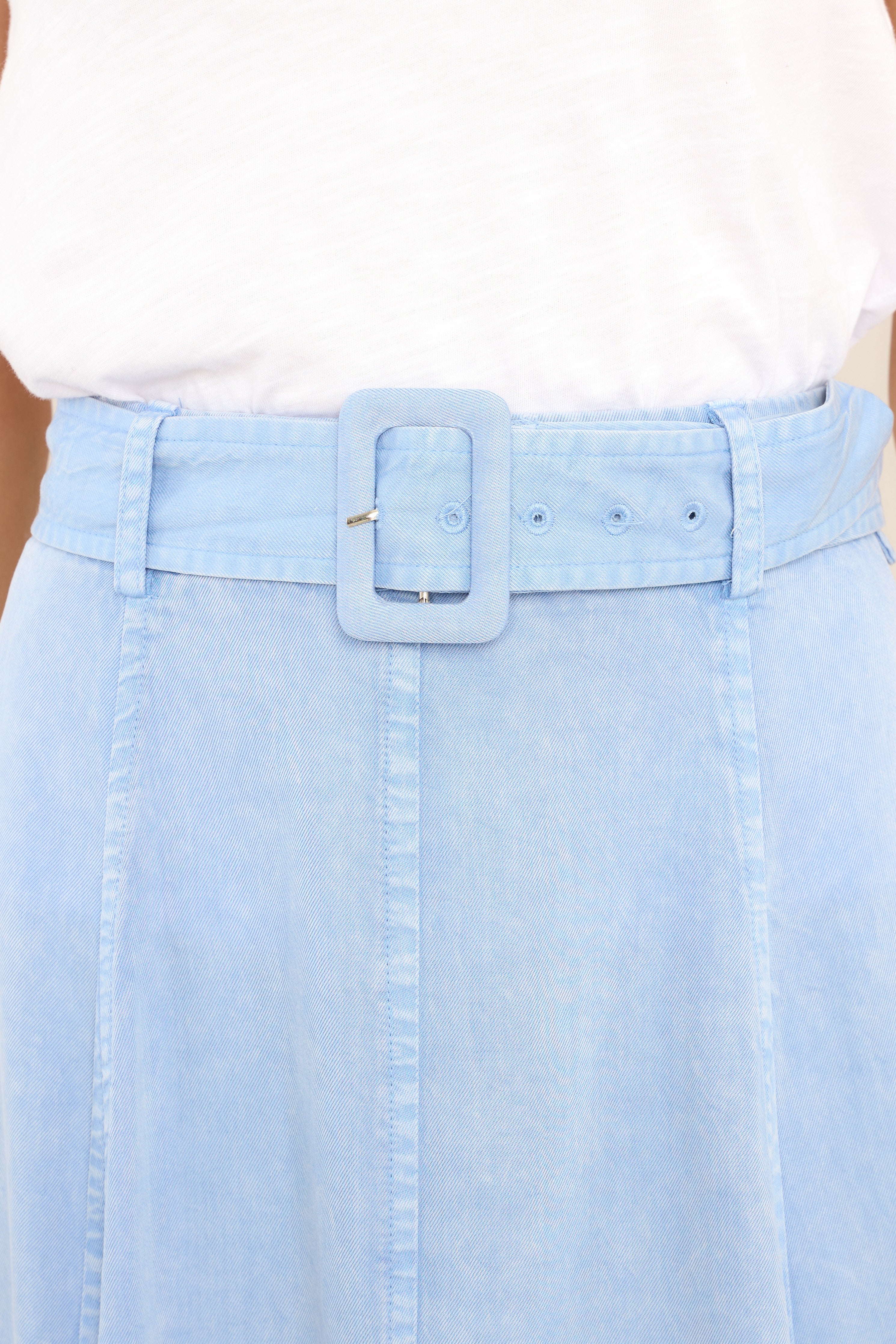 Close up view of this skirt that features a high waisted design, belt loops, and a functional belt.