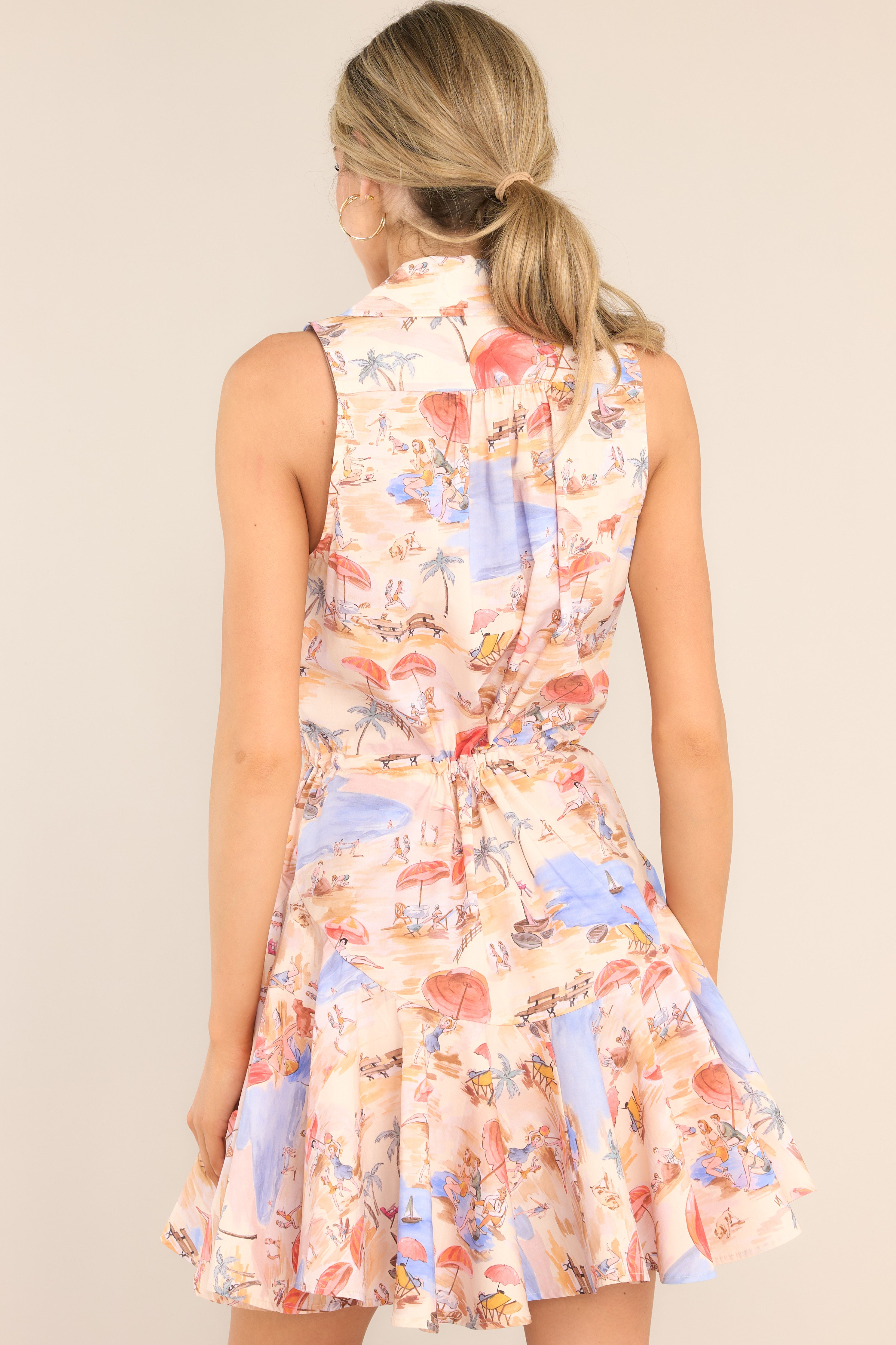 Back view of this dress that features a collared neckline, functional buttons, a self-tie waist feature, and a flowy skirt.