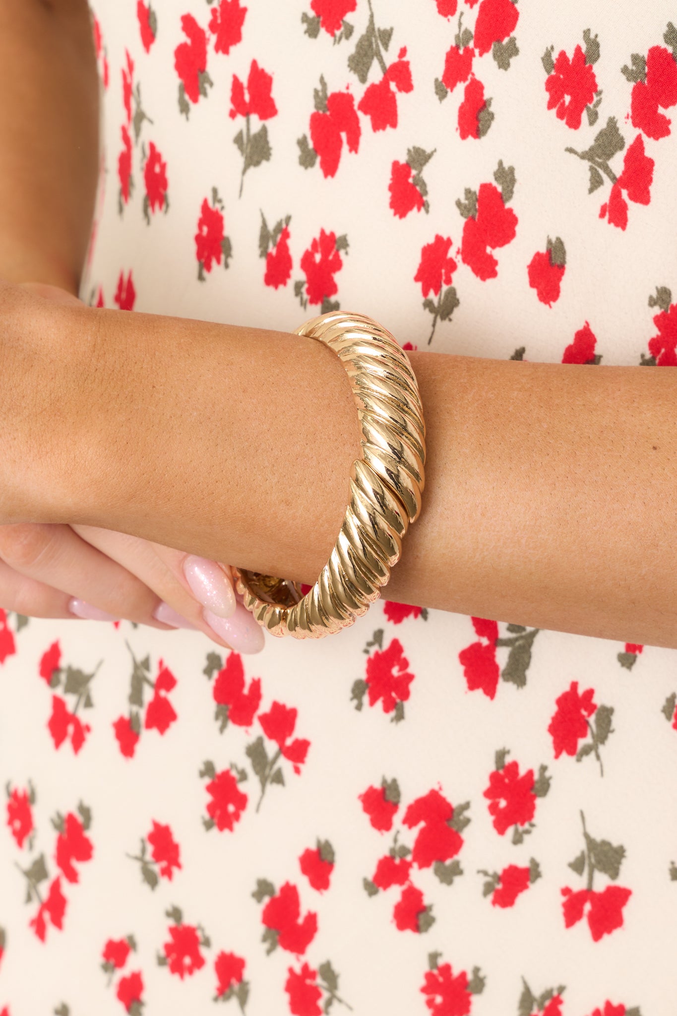 A focused shot emphasizing the bracelet's secure elastic bands and the intricate twists in the gold hardware.